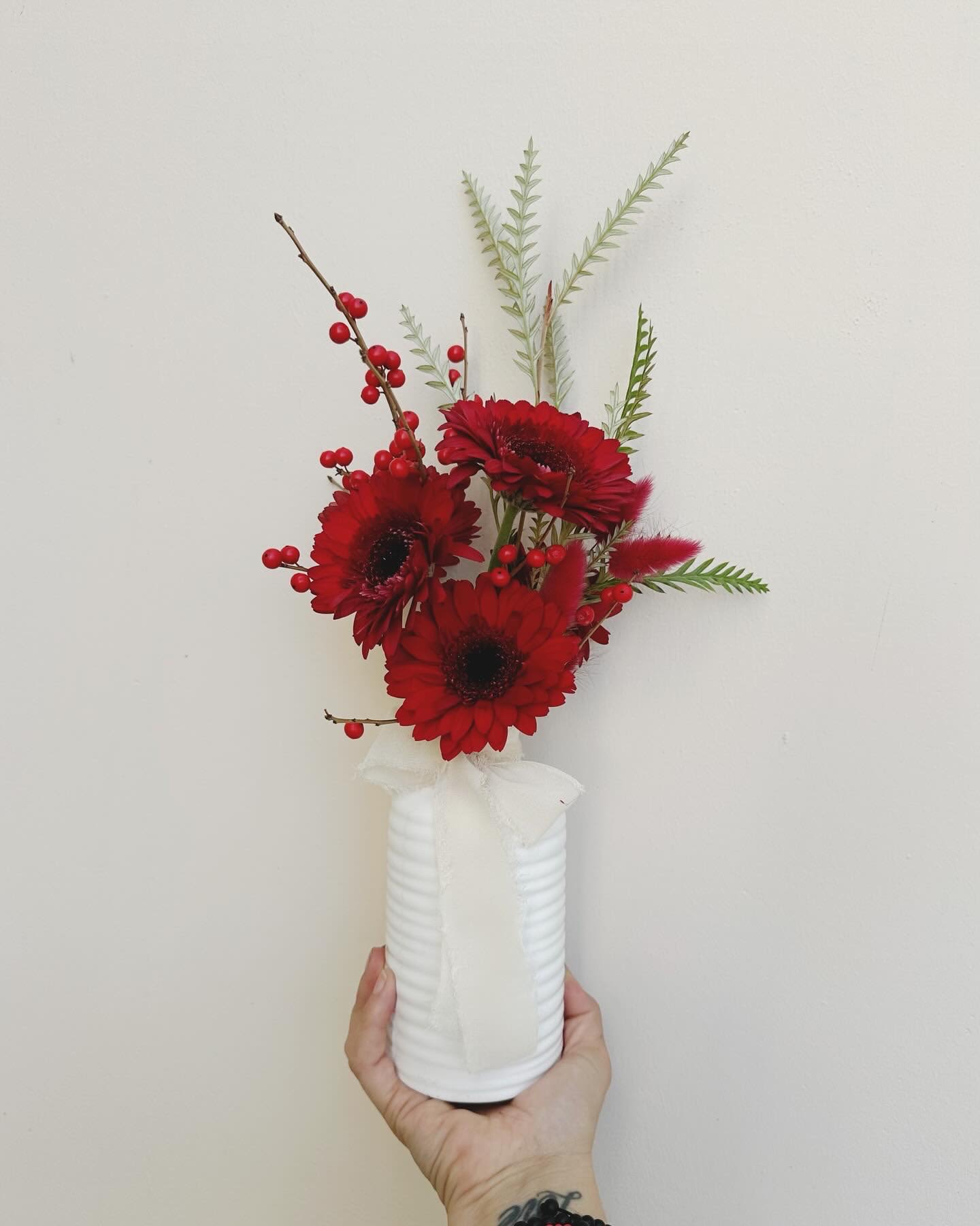 Holiday Bud Vase- tall - A tall, white ceramic bud vase mixed with green, red and white seasonal flowers.  Flowers will vary depending on availability!!!