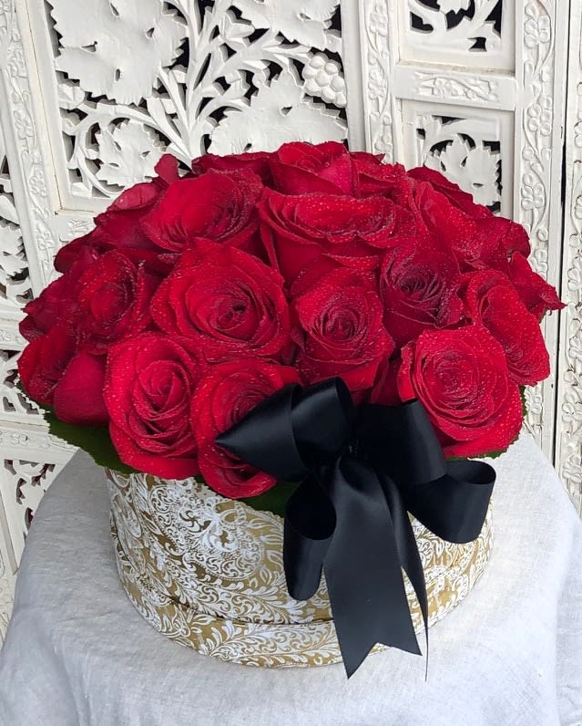 Rose Box - Please note the rose box pictured is the PREMIUM or 2 DOZEN size.  Gorgeous, velvety red roses presented in a gold and white box and simply accented with minimal greens and a satin bow. Please specify one dozen or two dozen and your preference for either classic ivory or sophisticated black satin ribbon. Perfectly elegant!  