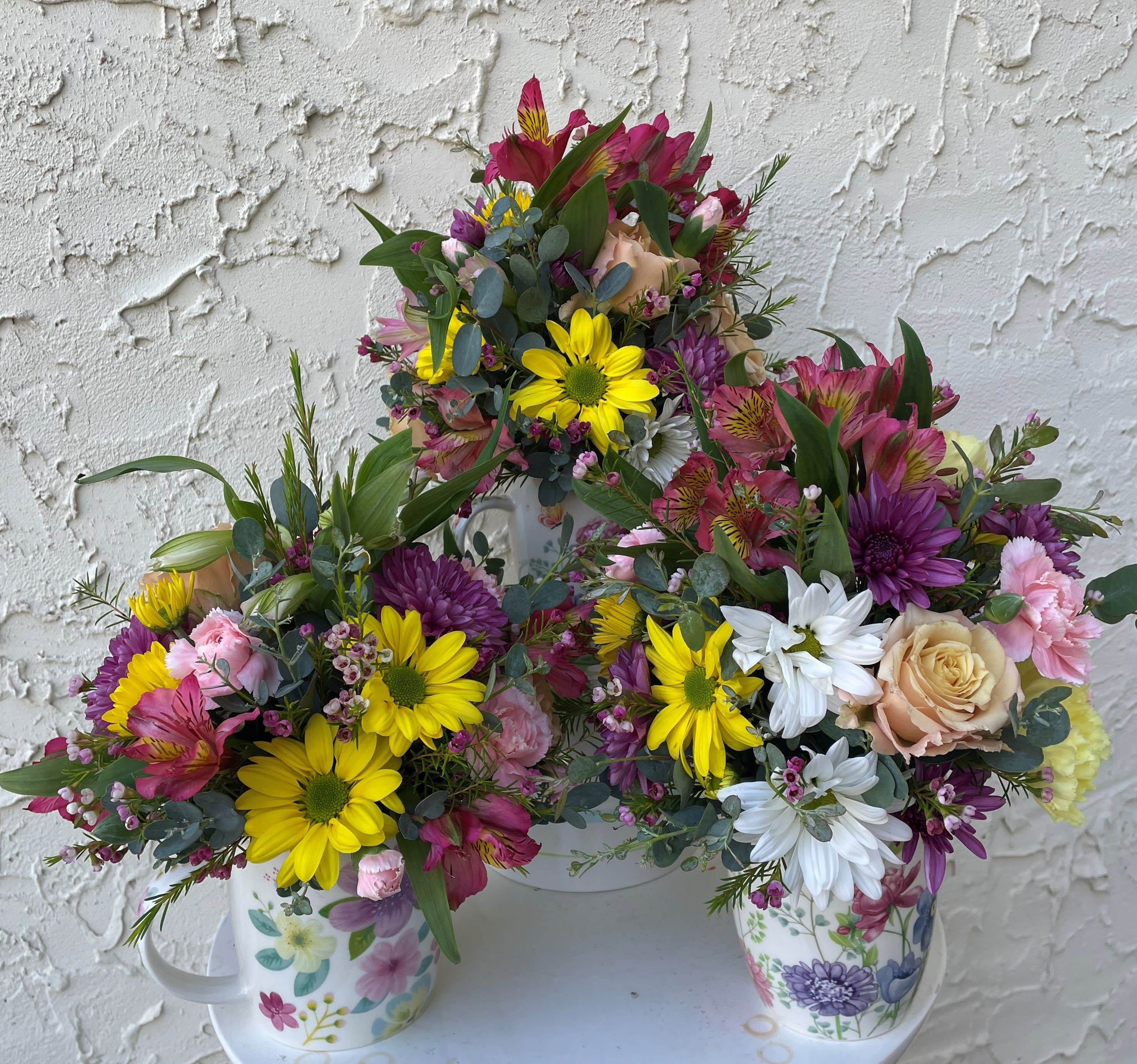A Cup of Joy - A sweet arrangement of a garden variety displayed in a mug as a keepsake gift. 