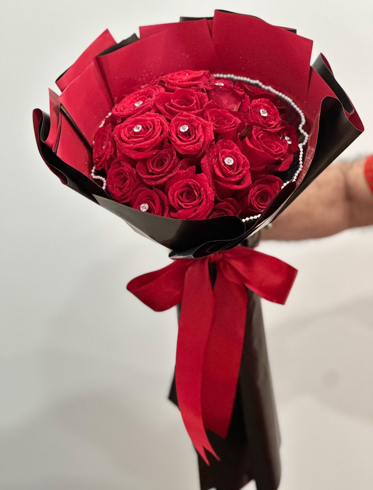 My Woman - A 24 bouquet of vibrant red roses adorned with delicate pearl accents, elegantly wrapped with matching red and black paper.