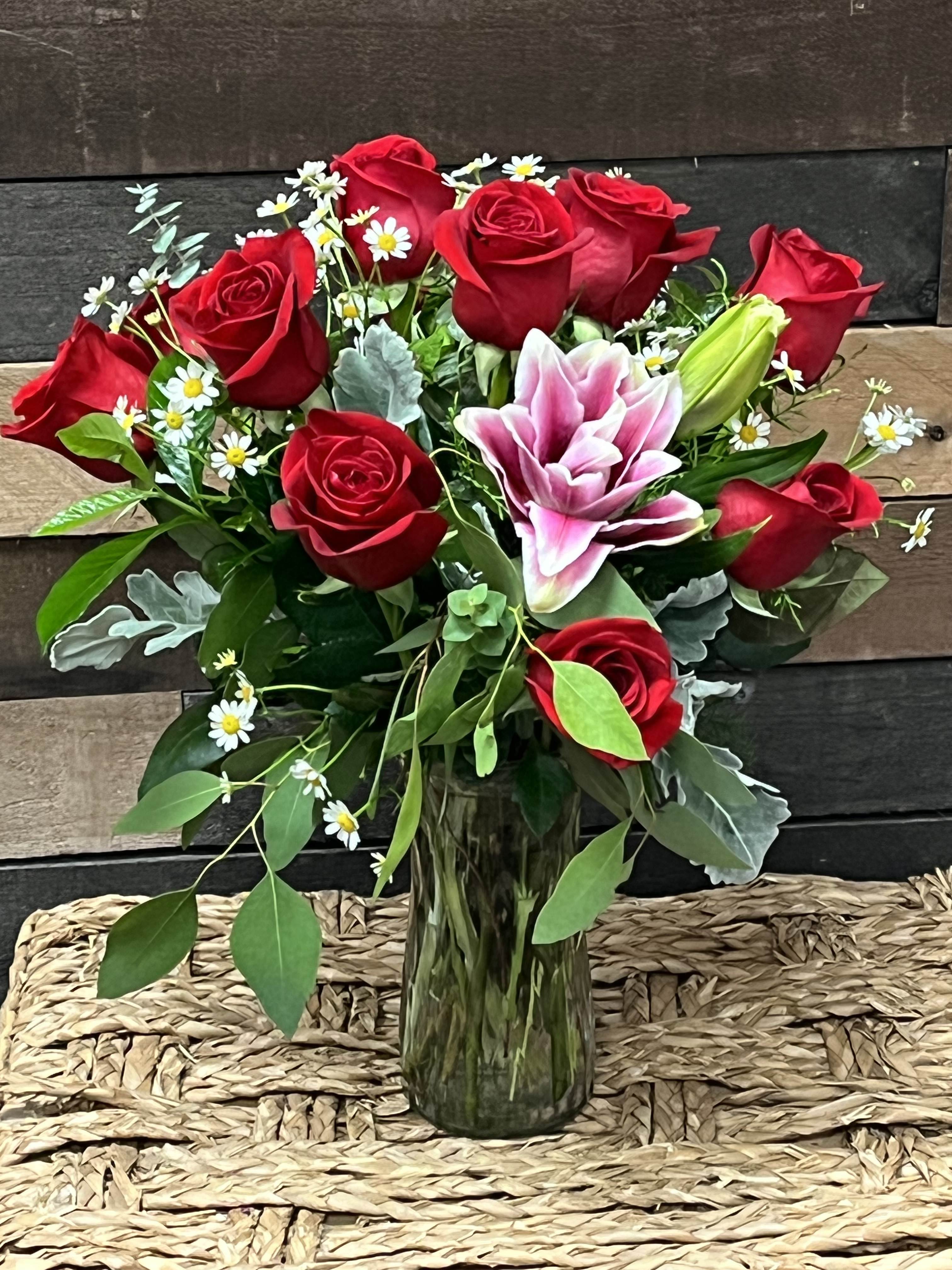 Love's Perfect Dozen Love's Perfect Dozen - The "Love's Perfect Dozen" arrangement features twelve red roses paired with elegant lilies and lush greenery, symbolizing deep affection and enduring passion.