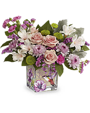 Humming Bird Surprise - A sweet surprise, this feminine rose bouquet is perfectly presented in a whimsical hummingbird-adorned cube vase. Pink spray roses, pink alstroemeria, miniature lavender carnations, lavender cushion spray chrysanthemums, green button spray chrysanthemums and pink sinuata statice are arranged with dusty miller and lemon leaf.  Delivered in Teleflora's Sweet Hummingbird Cube. (z)