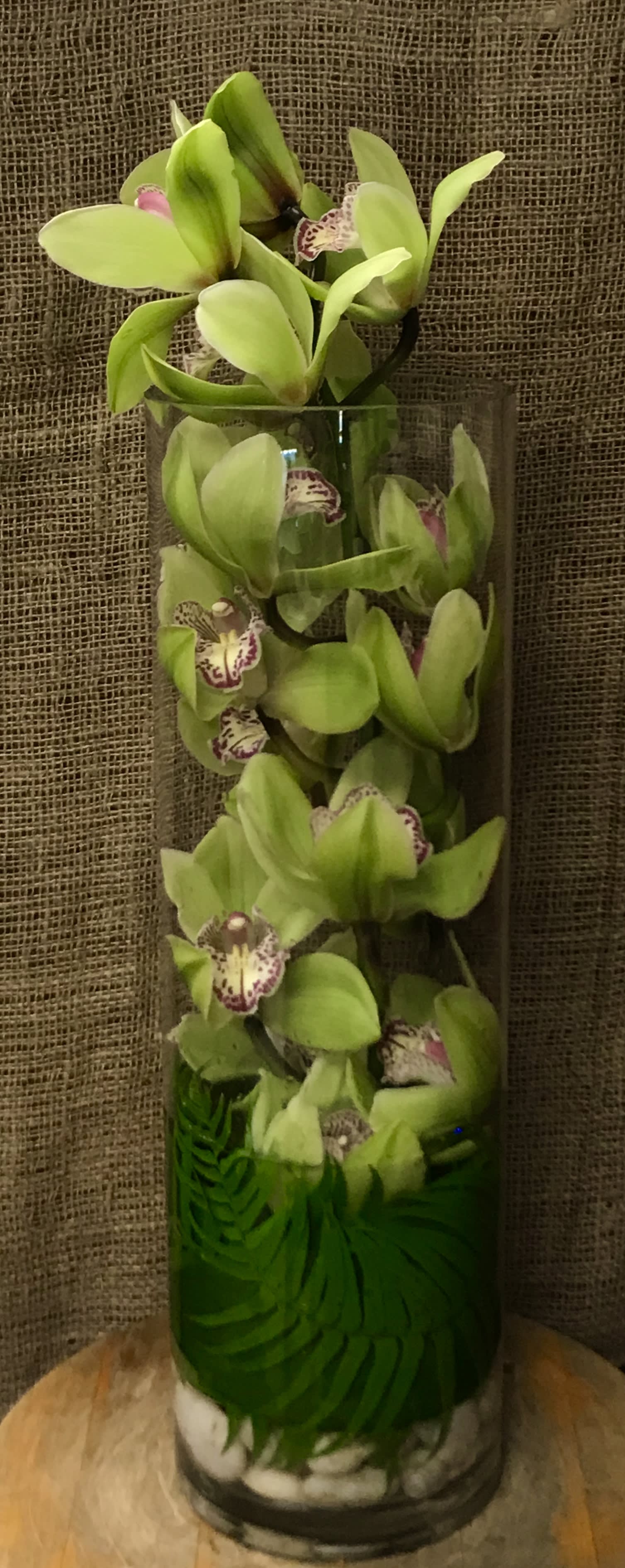 Underwater Orchid  - Submerging orchids in water is a clear and beautiful way to display them; and this tall column vase filled with orchids – a unique floral arrangement that will be lovely in any environment.  More colors available, pink, white, green, orange, yellow. Ask to see what's avaialble
