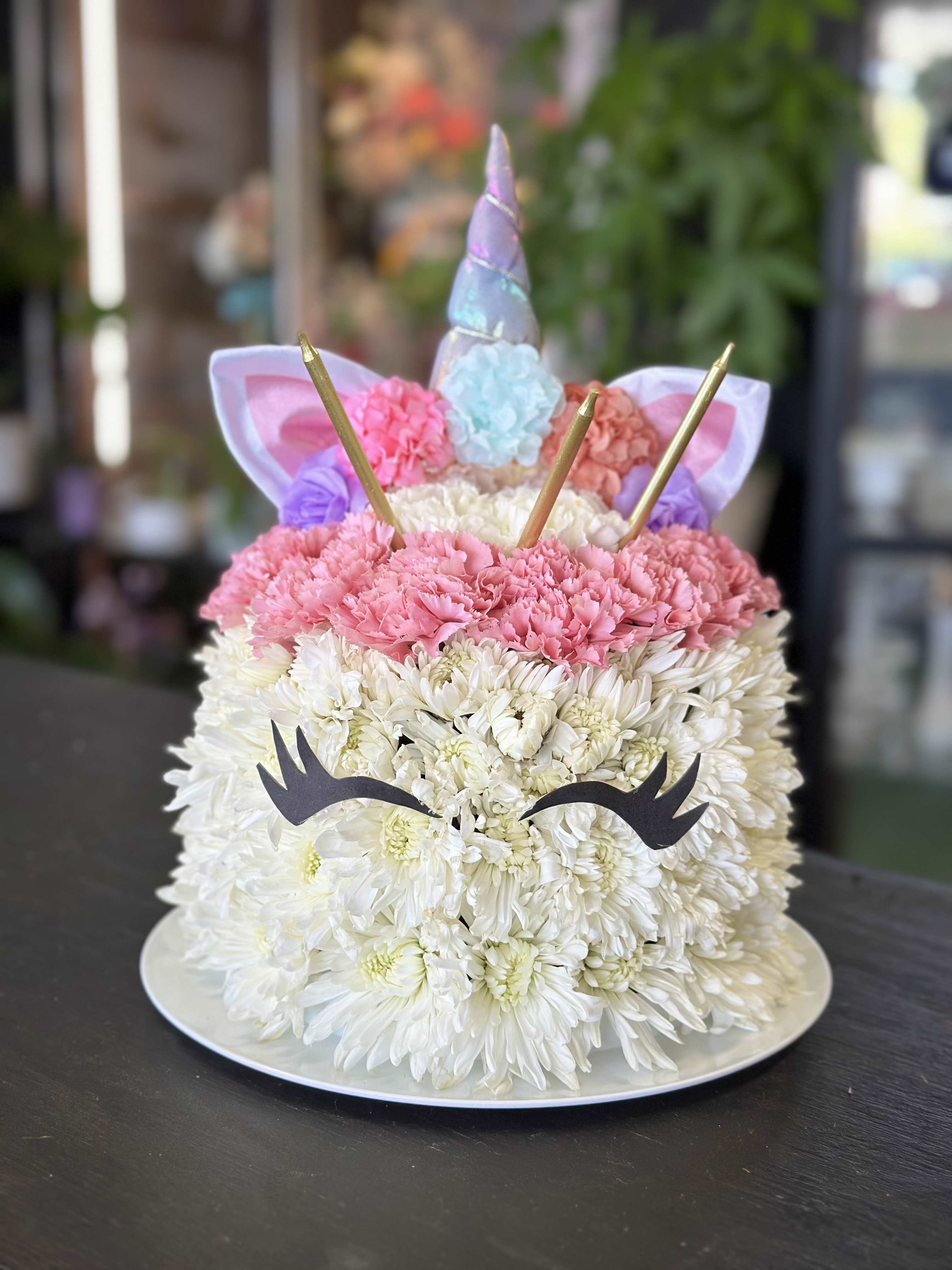 Flower Birthday Cake Flower Birthday Cake - We can do many different kind of flowers birthday cakes and custom designs too. This is a unicorn birthday cake. It is over 12" tall with unicorn horns and candles on top.
