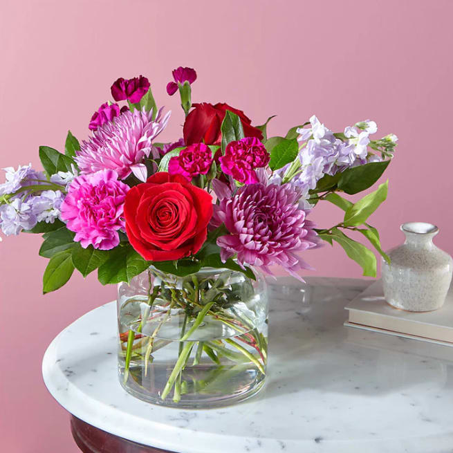 My Everything Bouquet - Show them they mean the world to you with this ample blend of red roses and purple carnations in a cinched glass vase.  Please Note: The bouquet pictured reflects our original design for this product. While we always try to follow the color palette, we may replace stems to deliver the freshest bouquet possible, and we may sometimes need to use a different vase.