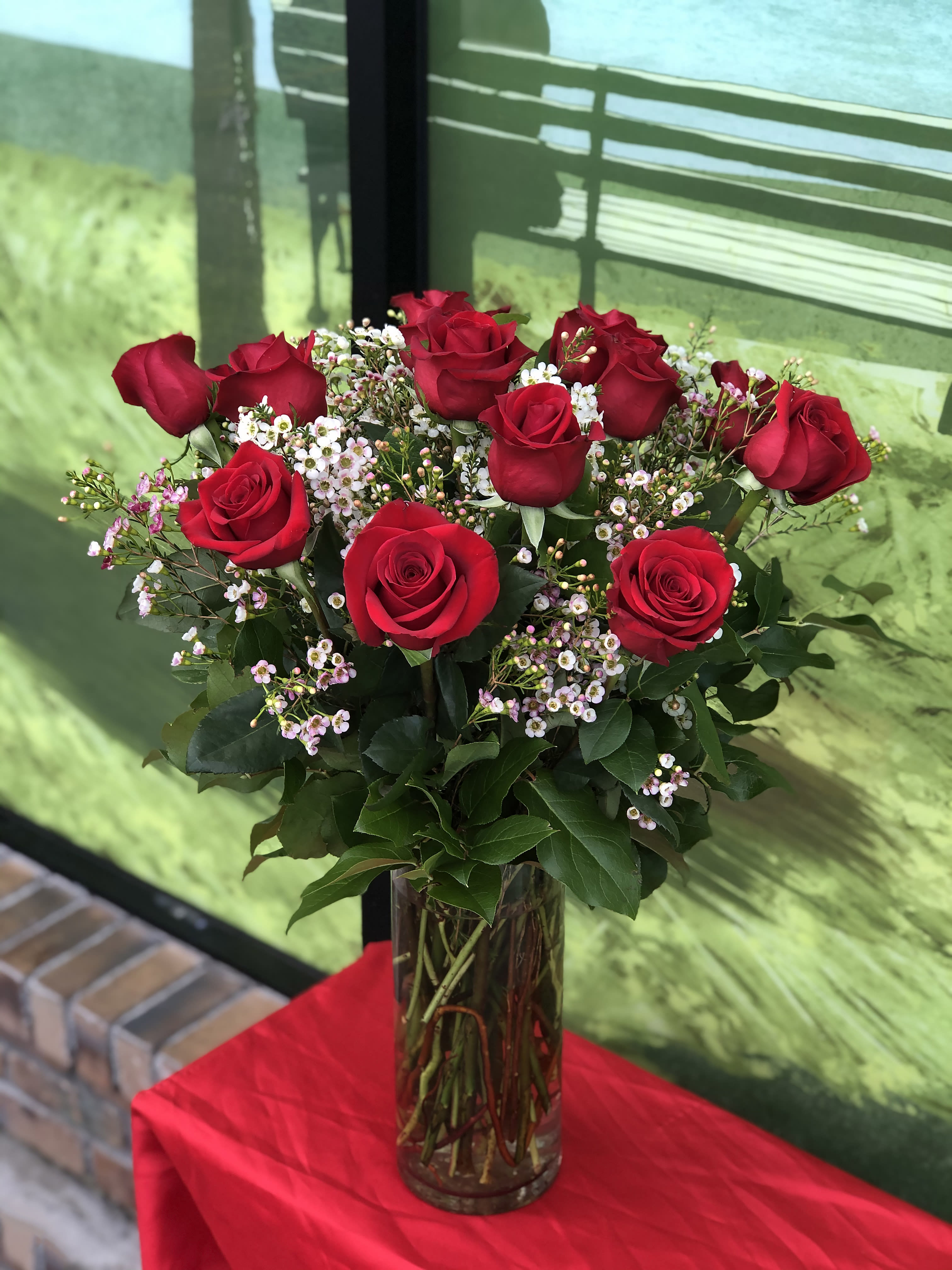 One Dozen Rose In a Vase  - One Dozen rose in vase with filler and greens to make any occasion special   Approximately 29&quot; high and 25&quot; wide All of our Roses are premium long stem ecuadorian roses!