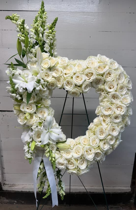 Eternal Love Heart Wreath - A pristine, elegantly designed wreath made of white roses accented with lilies and snapdragons. The wreath can be designed using any color of roses or a combination of colors. 