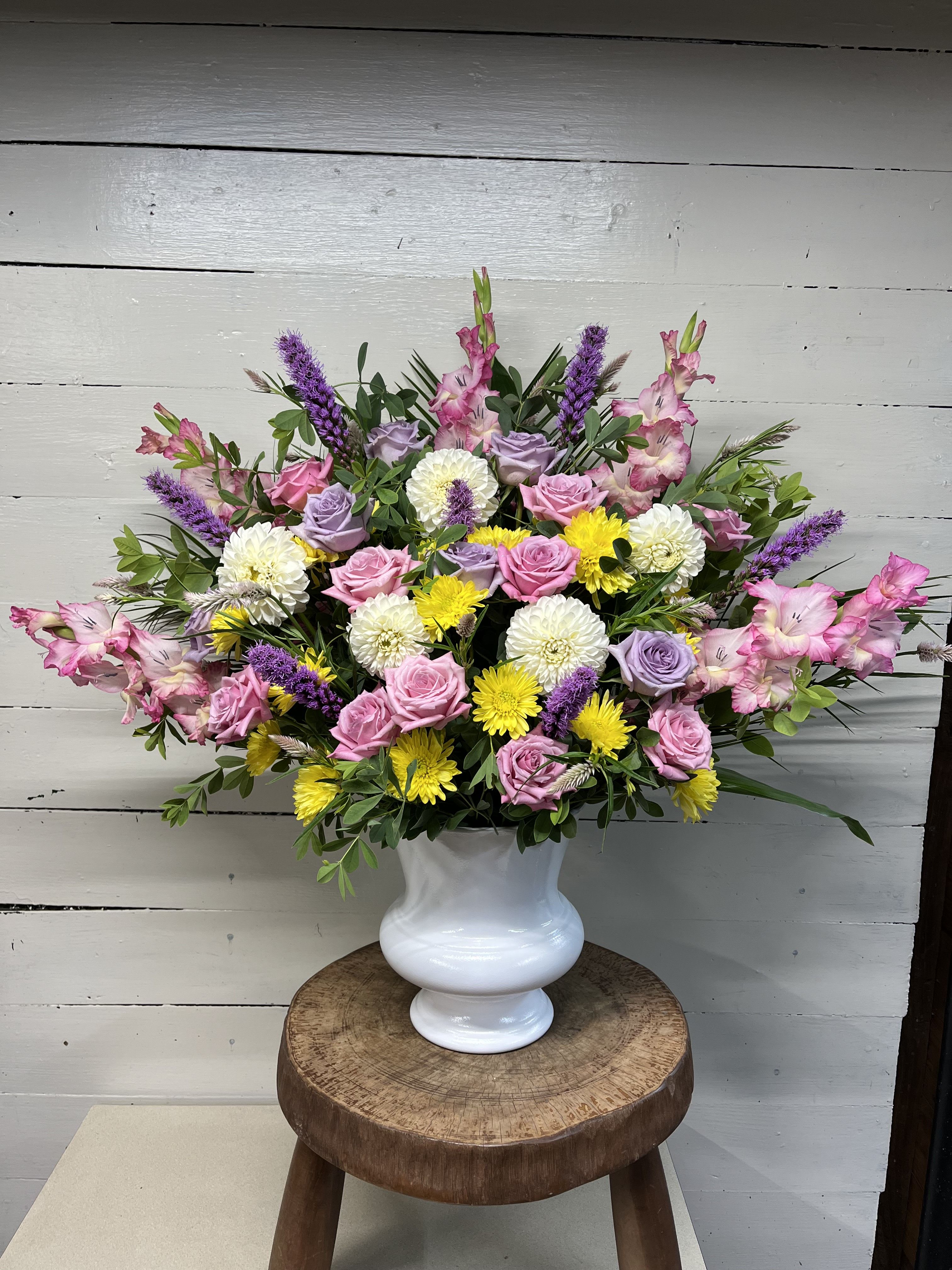 Blossoming Hope - A soothing palate of pinks, lavender, purple, yellow, and white blooms create a stunning floral farewell. 