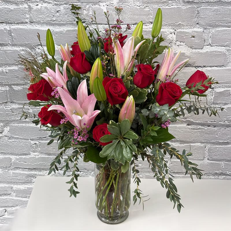 Love Without Limits - STUNNING! Vase of red roses, pink or white  lilies, eucalyptus, seasonal filler (accent) flower all combine in this glass vase to get your point across!