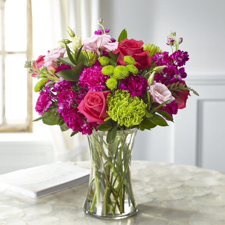 Everlasting Embrace Bouquet - Share your love and sympathies with our Everlasting Embrace Bouquet. A collection of roses, lisianthus, stock and Fuji mums are crafted in a clear vase to evoke the same warmth that comes from a comforting embrace. 