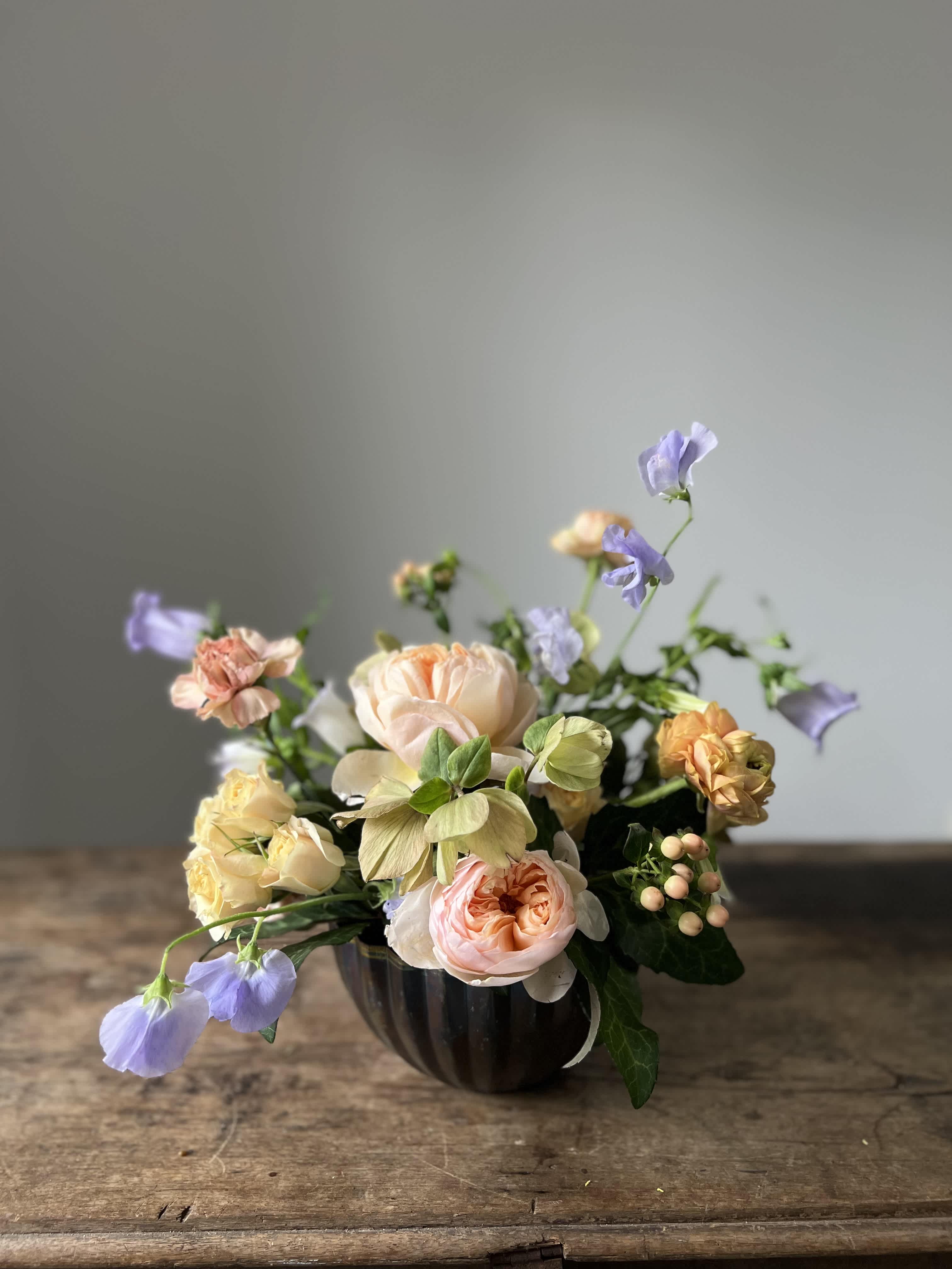 Bowl of Peaches Bowl of Peaches - This beautiful pressed metal bowl with varied patina showcases premium blooms in a serene palette of peach, green, and lavender. Presented in gift bag with tissue