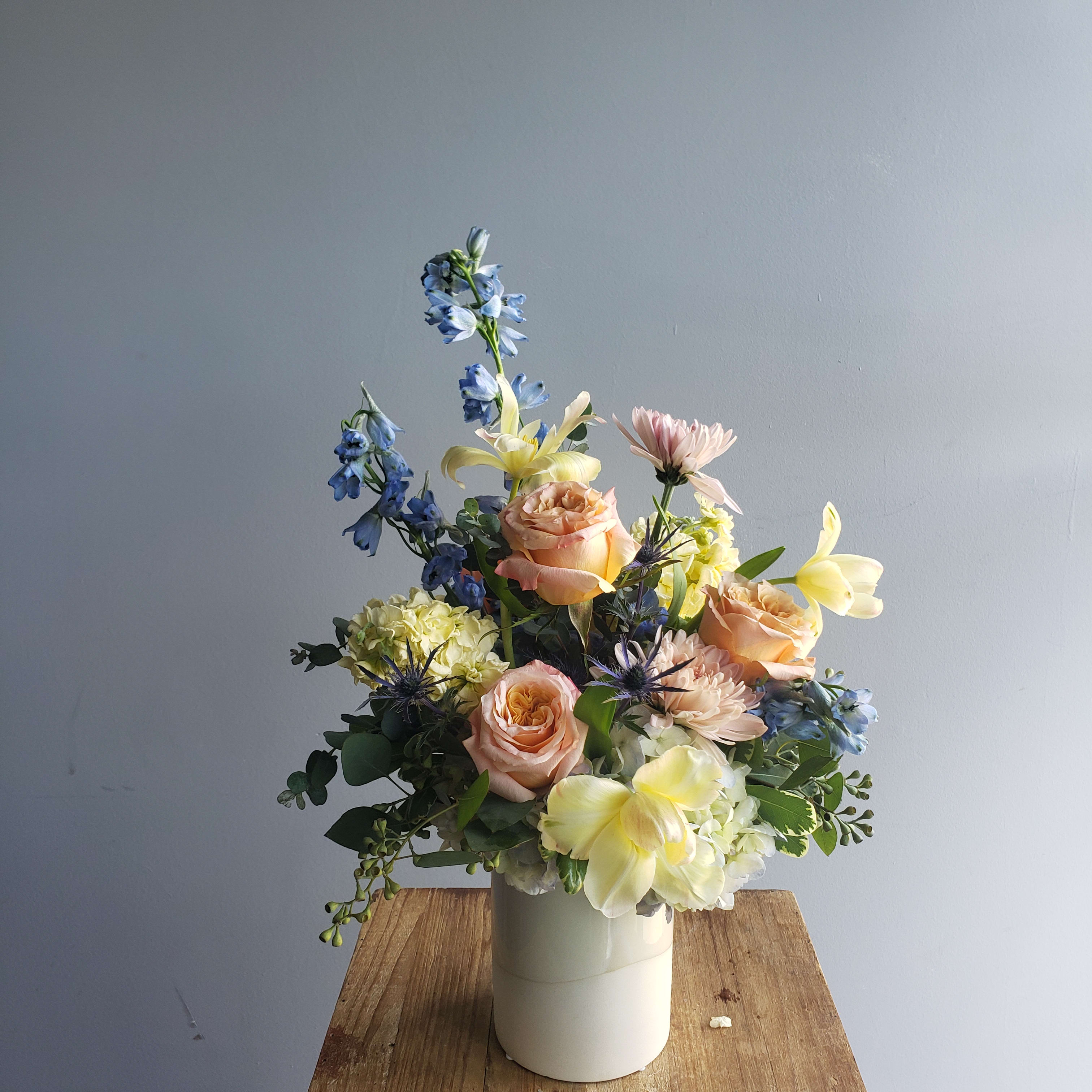Soft Sunset - Warm buttery sunset tones of roses, stock, tulips and delphinium in glass or ceramic vase.