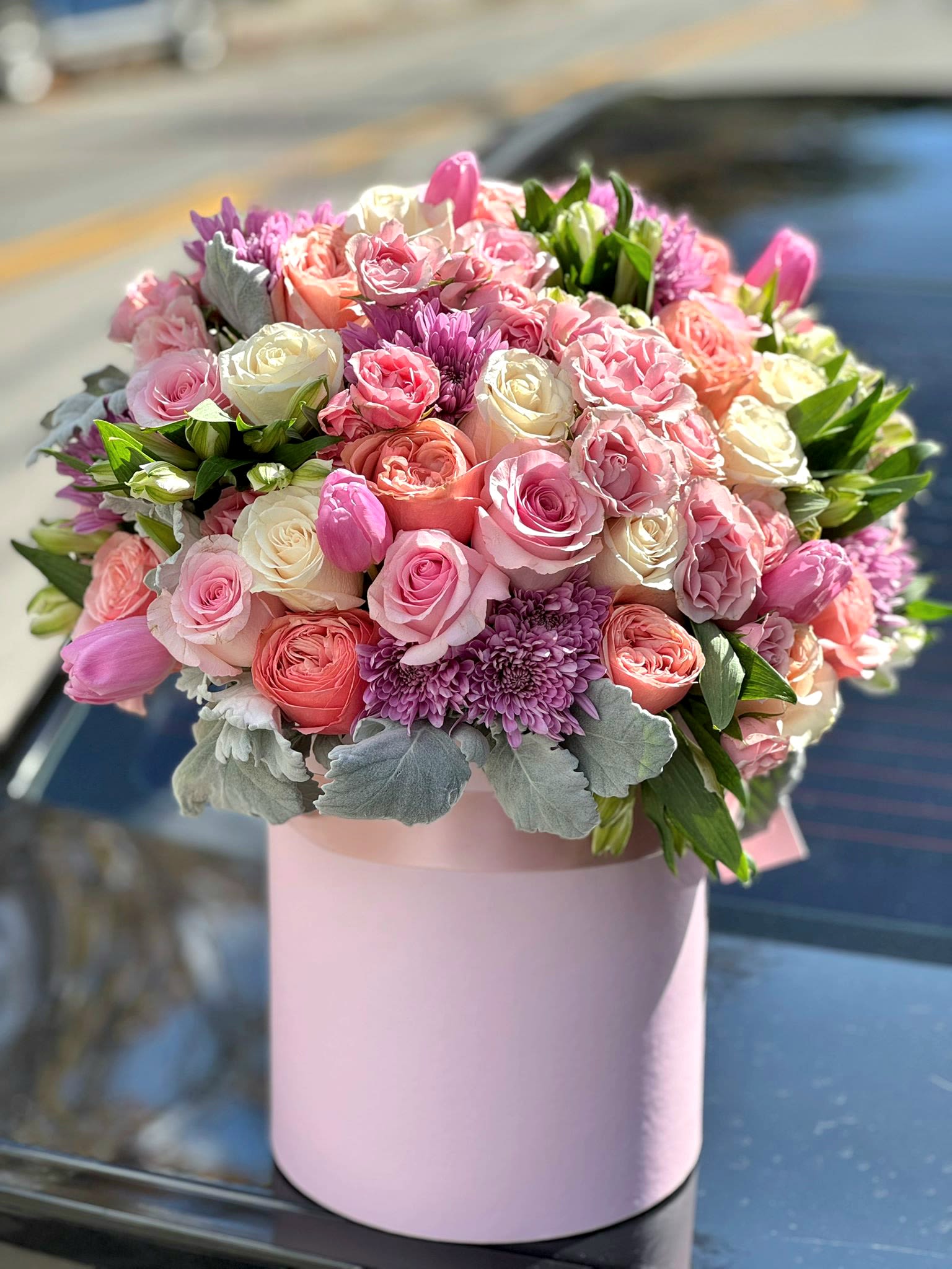 Melody Flowers  - This luxury hatbox arrangement features premium roses, tulips, and ranunculus in soft pink hues, perfect for upscale gifting. Designed for high-end floral delivery, it’s ideal for birthdays, anniversaries, and special occasions