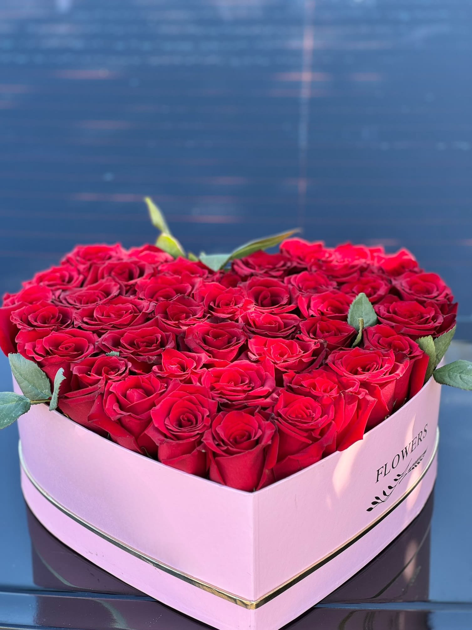 Thinking of You  - Delicate red roses cradled in a heart-shaped hatbox, a flawless expression of affection for your beloved. Let your love bloom, suffused with the sweetest essence of romance  