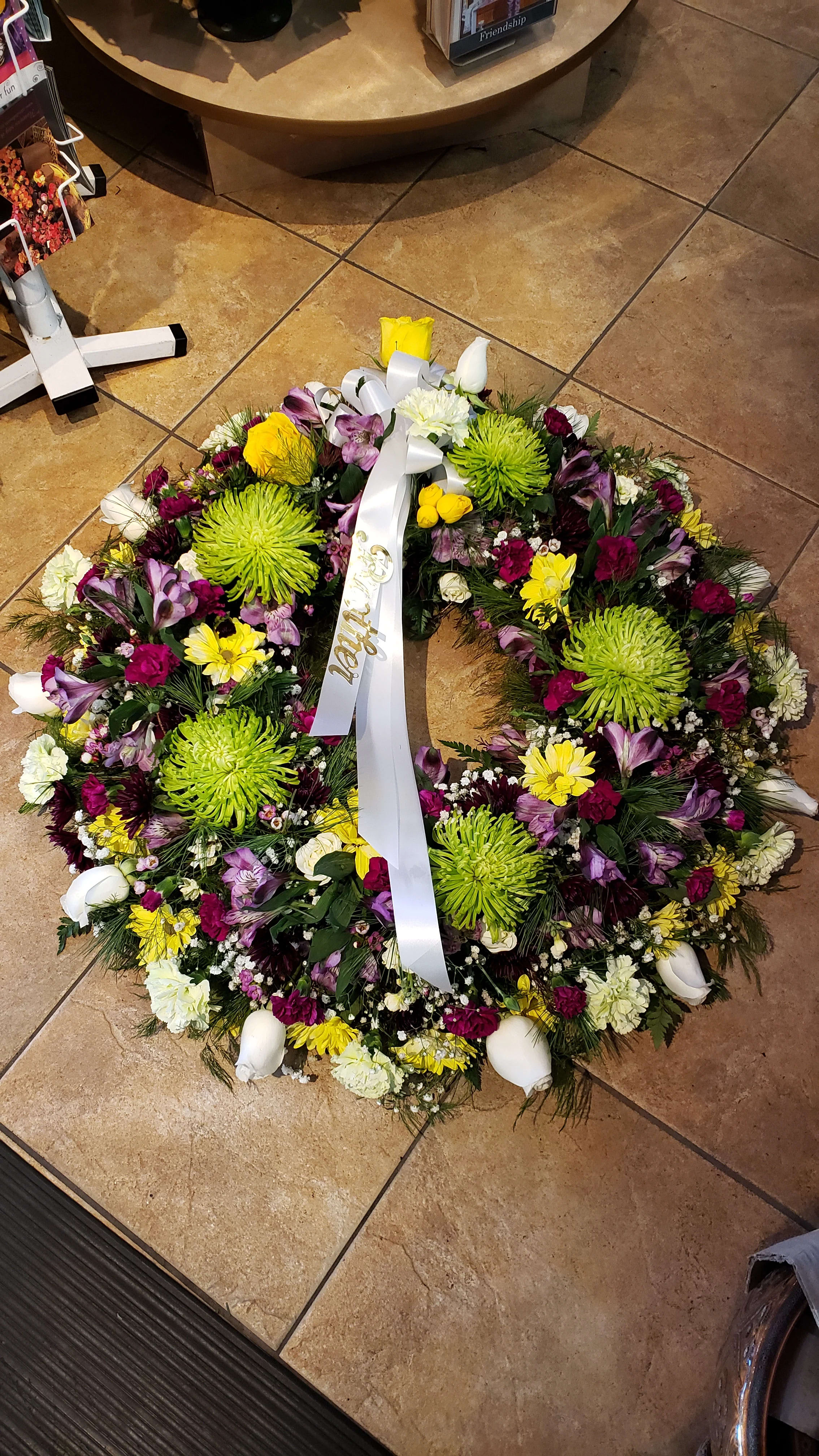 Garden Wreath   - Wreath Tribute of a mixed colors &amp; flowers for a seasonal theme.  Colors will vary based on market fresh inventory at time of order &amp; service delivery deadline.  Please call to discuss or note 1st &amp; 2nd choice in preference.  We cannot guarantee this color or flower theme...photo sample only!  Traditional in size and loads of texture!   