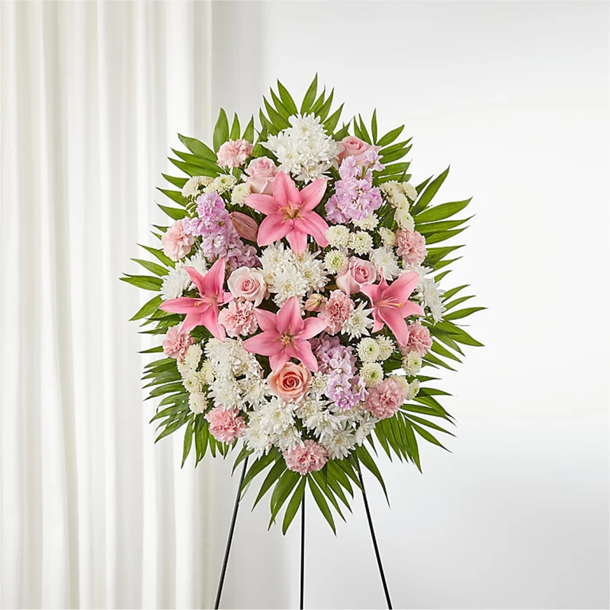 Offering Solace Standing Spray - Artfully arranged pink and white florals create a captivating standing spray to honor a beautiful life. This standing heart is perfectly fit to honor your most loving friend or family member who has passed. Appropriate for the funeral home, memorial service, or gravesite.  DETAILS Pink roses, pink carnations, white button-mums, white cushion-mums, pink stock, and pink Asiatic lilies: accented with palm leaves.   EASEL INCLUDED Orientation: One-Sided Item #NF-1163  FLORIST-TO-DOOR Same day flower delivery on most orders placed online by 12 pm or 10 am on weekends PST.  BLOOM DETAILS Roses Button-Mums Stock Cushion-Mums Carnations Asiatic Lilies Greenery  The Standard Arrangement is approx. 34&quot;H x 38&quot;W without an easel. The Deluxe Arrangement is approx. 40&quot;H x 31&quot;W without an easel.  The Premium Arrangement is approx. 44&quot;H x 33&quot;W without an easel.  INSTRUCTIONS: 1.) Please have the business name of the funeral home, address &amp; phone number. 2.) Please have the first name &amp; last name of the deceased. 3.) Please have the start time of the services.  How to place an order?  1. You can place an order directly on this secure website. OR 2. You can call in your order by dialing: (323) 262 - 9238. OR 3. You can visit our store (appointment recommended 323.262.9238)  NINFA'S FLOWERS 2405 WHITTIER BLVD. LOS ANGELES, CA. 90023