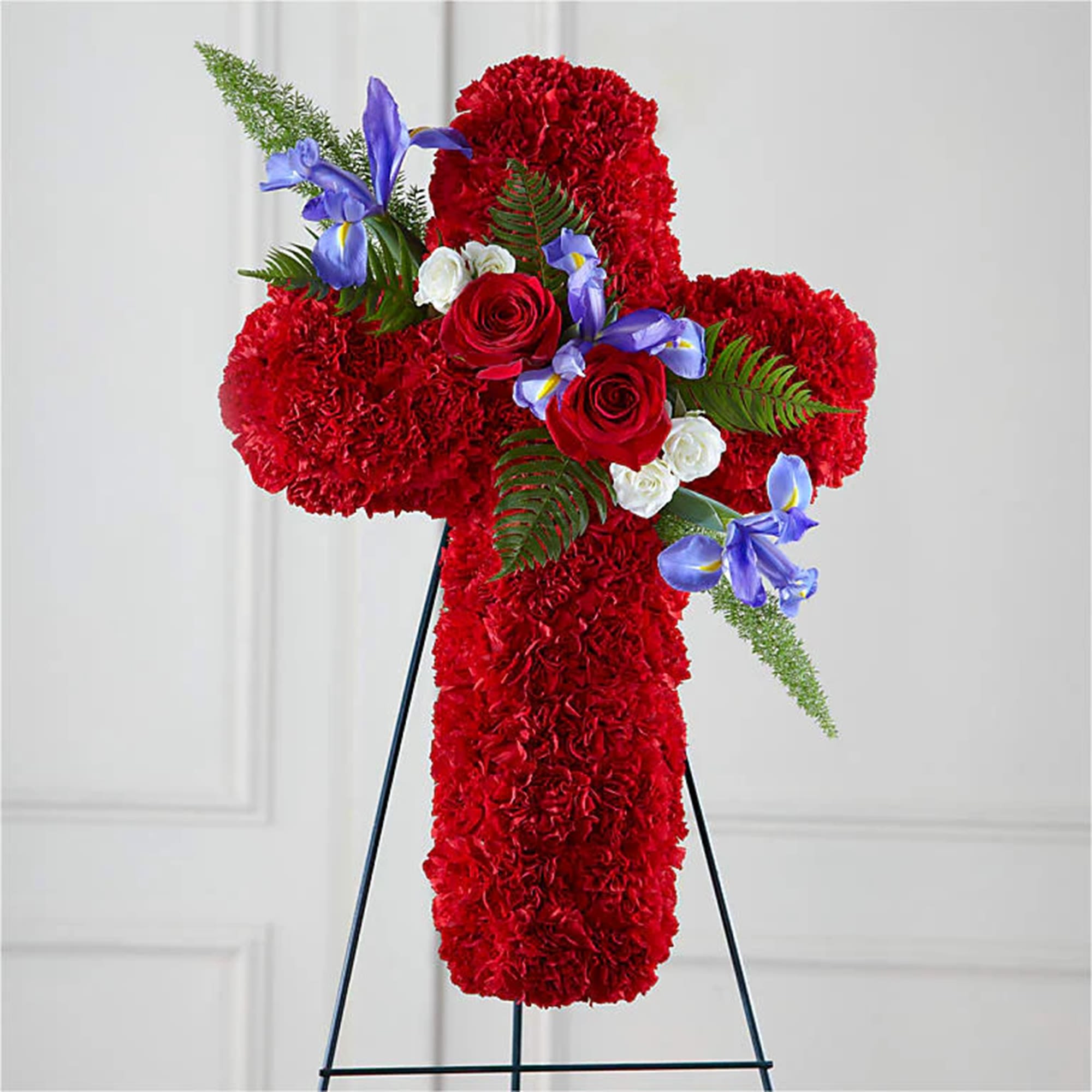 Faithful Hero Floral Cross - This thoughtful and meaningful tribute is a vibrant expression of faith. This graceful cross handcrafted by our artisan designers of bright red carnations, blue iris, roses and other complementary greenery makes a powerful statement that’s sure to be remembered and appreciated. This floral tribute is a beautiful way to offer peace and comfort during a difficult time. Appropriate for the funeral home, memorial service, or gravesite.  DETAILS Red carnations, white spray roses, blue Iris, red roses and greenery.   EASEL INCLUDED Orientation: One-Sided *If you would like to add a ribbon with a sentiment for an additional $10 each. Item #NF-1165  FLORIST-TO-DOOR Same day flower delivery on most orders placed online by 12 pm or 10 am on weekends PST.  BLOOM DETAILS Carnations Spray Roses Roses Iris Greenery  The Standard Arrangement is approx. 24&quot;H x 18&quot;W without an easel.  The Deluxe Arrangement is approx. 26&quot;H x 20&quot;W without an easel.  The Premium Arrangement is approx. 28&quot;H x 22&quot;WL without an easel.   INSTRUCTIONS: 1.) Please have the business name of the funeral home, address &amp; phone number. 2.) Please have the first name &amp; last name of the deceased. 3.) Please have the start time of the services. 4.) If you would like for us to write a brief message on a small business card-size note, please have your message ready.  NINFA'S FLOWERS 2405 WHITTIER BLVD. LOS ANGELES, CA. 90023