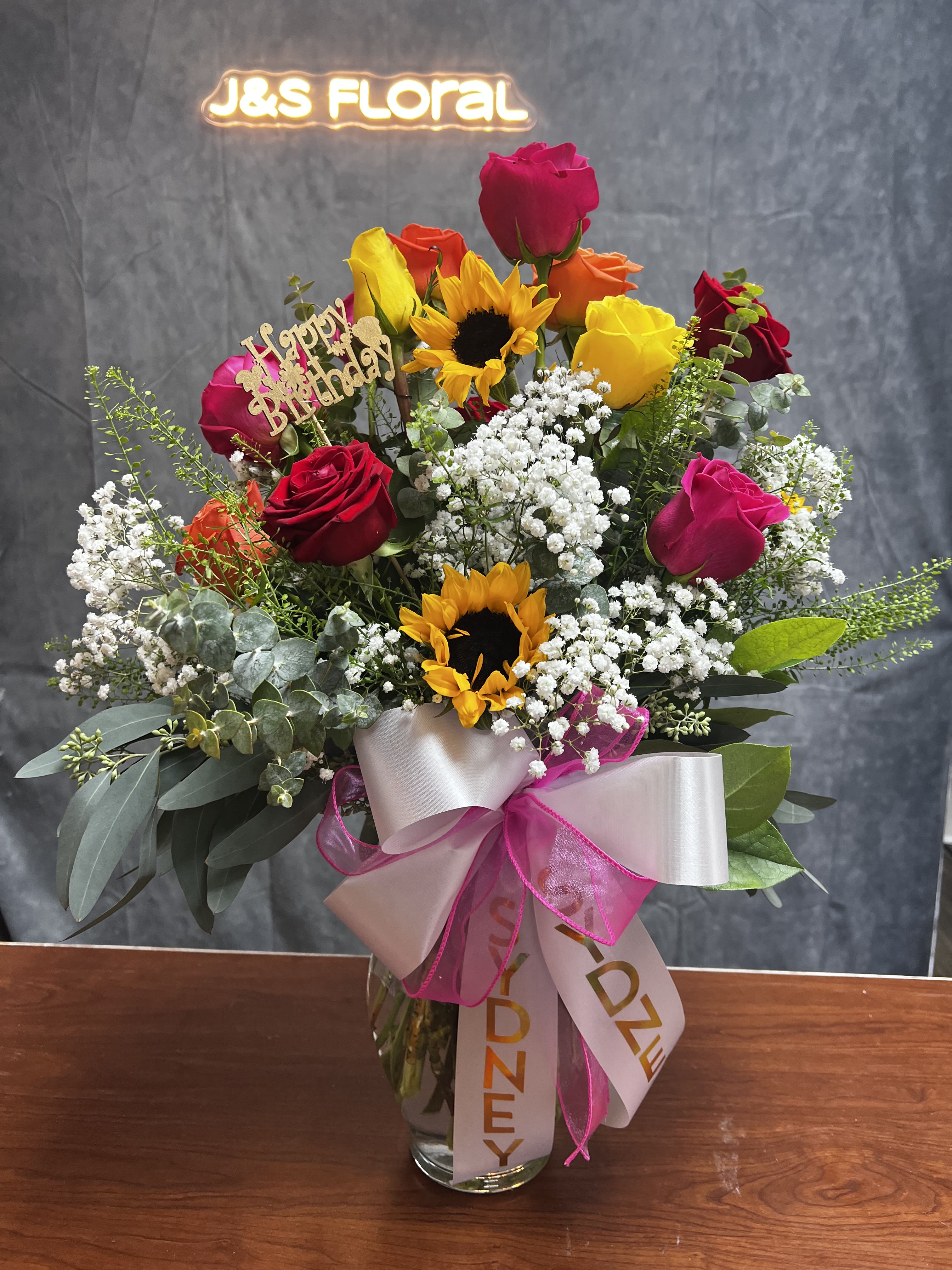 Sunshine and Roses  - Introducing our vibrant sunflower and rose vase, a perfect blend of warmth and beauty. The cheerful sunflowers bring a burst of sunshine, while the elegant roses add a touch of romance. Ideal for any occasion, this lively arrangement brightens up any space and spreads joy!  