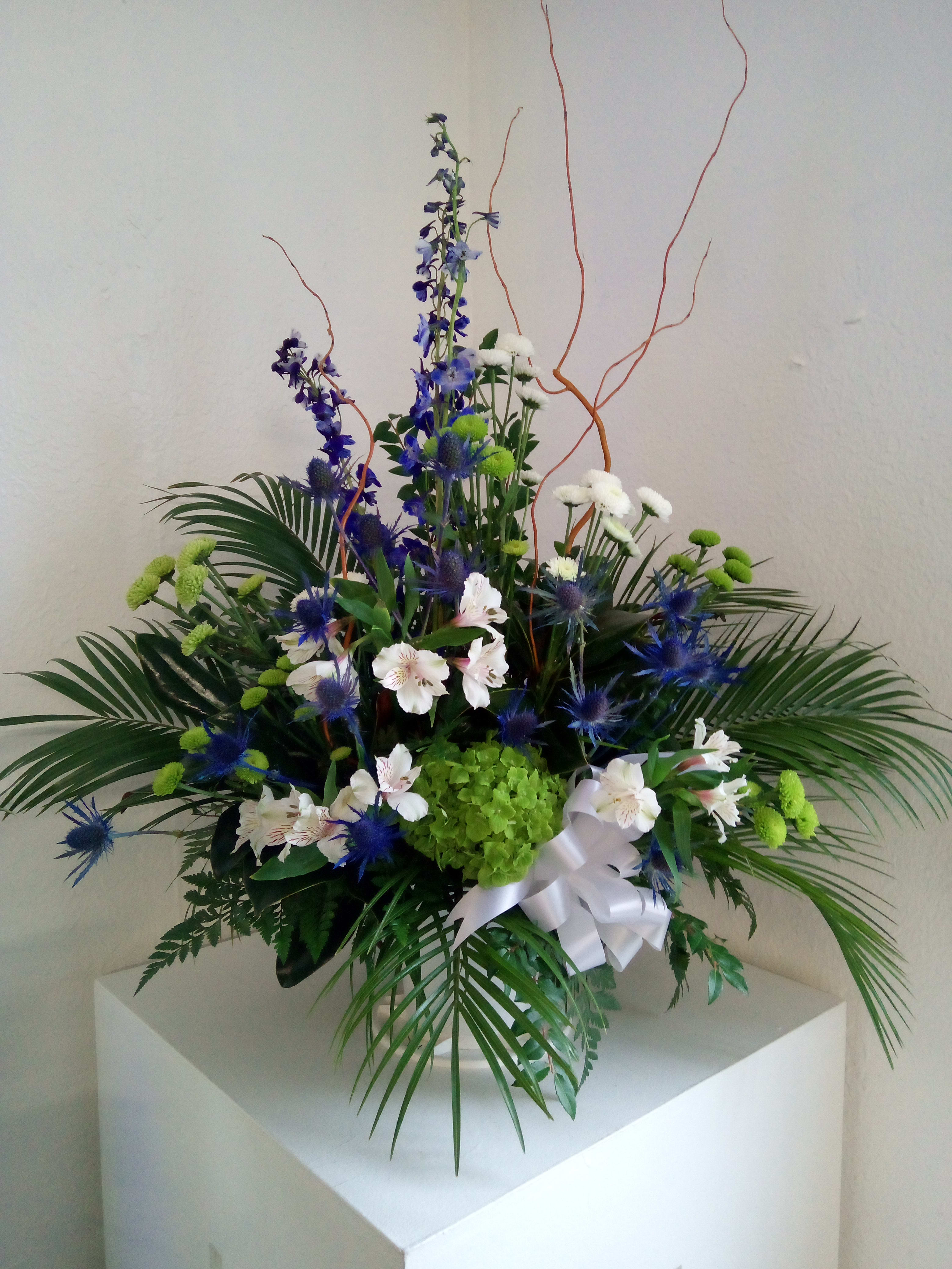 Treasured memories - Blues, whites and greens make up this beautiful arrangement with a touch of tropical greenery.