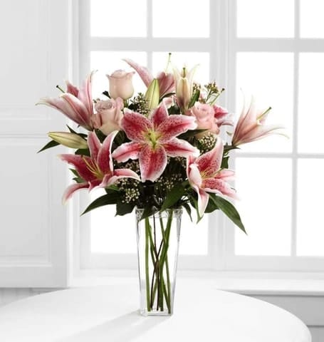 SIMPLE PERFECTION SIMPLE PERFECTION - Speak from your heart to theirs with a collection of pink vibrant blooms. Pale pink roses collaborate with the magic of Stargazer lilies displaying their fragrant fuchsia petals amidst waxflower accents. Beautifully arranged in a clear square tapered glass vase, this bouquet sends your warmest sentiments with glamour and grace. Size: 22''x 18H