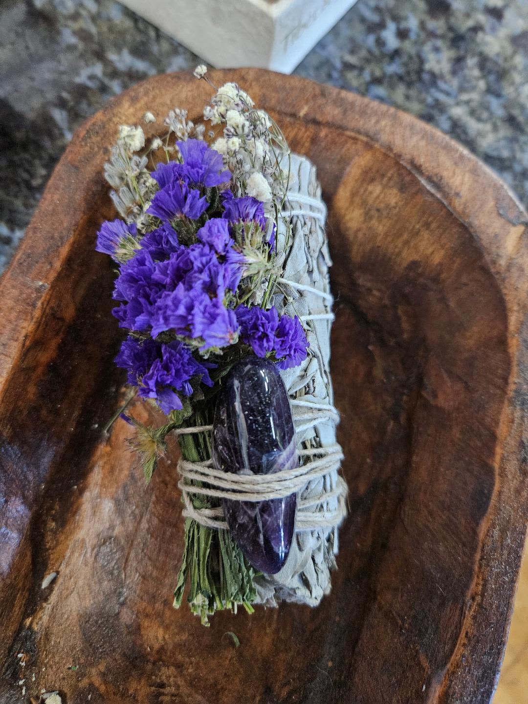 Floral Sage Amethyst Crystal Cleansing Bundle - About this product  Amethyst Spiritual Cleansing Bundle  This spiritual kit provides a peaceful, calming, energy to yourself, home, spirit, &amp; loved ones.  All sets are cleansed, &amp; handmade with love &amp; intentions.  Includes: •	1 - 4-inch White sage wand wrapped with Lavender, Baby’s Breath &amp; Purple Statice •	1 - Amethyst (Smooth) Crystal   White Sage (Salvia Apiana): Smoke cleansing w/white sage enhances meditation &amp; ritual by cleansing self &amp;/or space of negative energy.  The practice helps relieve your worries, opens your mind, &amp; clears away negative thoughts.  Our white sage is sustainably harvested in its native region of California.      Flowers/plants: Have their own frequencies &amp; healing properties.  We add fresh cuttings to our sage to create magickal combos.   •	Lavender brings tranquility &amp; peace.  It also helps with sleep, depression, &amp; anxiety.   •	Baby’s Breath represents the purity of emotion.   •	Statice the everlasting flower.  Remembrance and invites positive energy in.