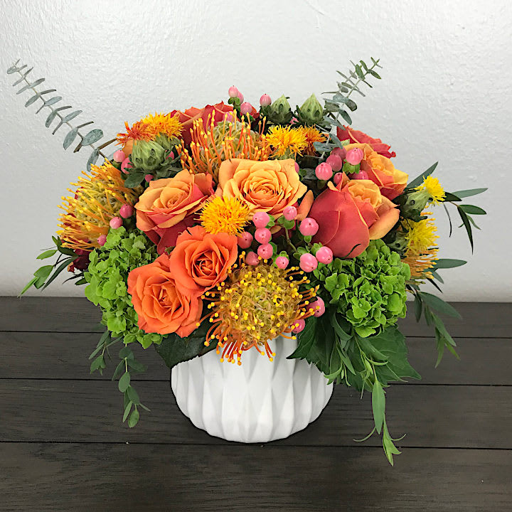 October Bloom - a blend of flowers with seasonal autumn hues in a white ceramic vase