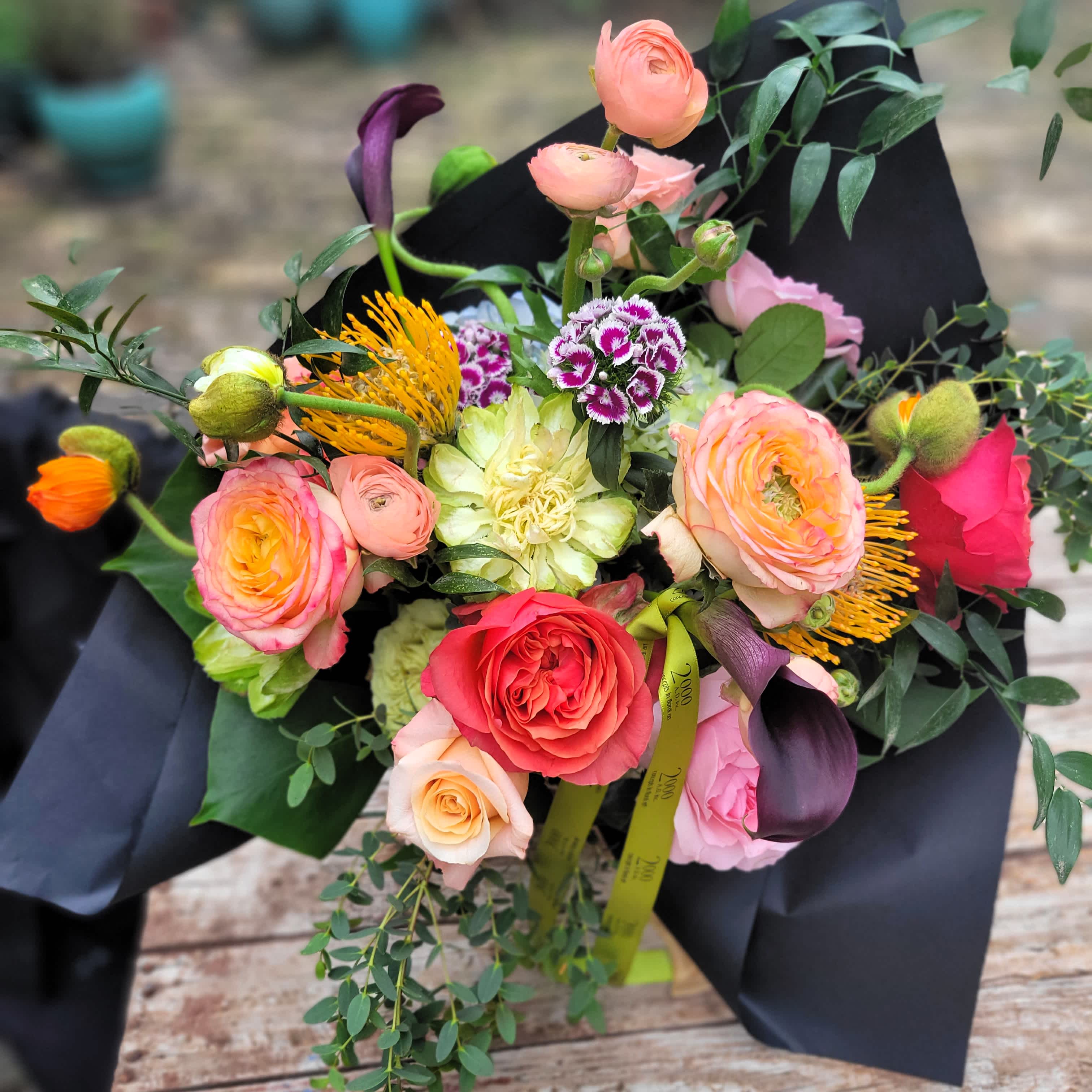 Expression of Love Bouquet Expression of Love Bouquet - Hand wrapped bouquet of colorful seasonal flowers presented in a black craft paper wrap with signature ribbon. In-store pick up only.