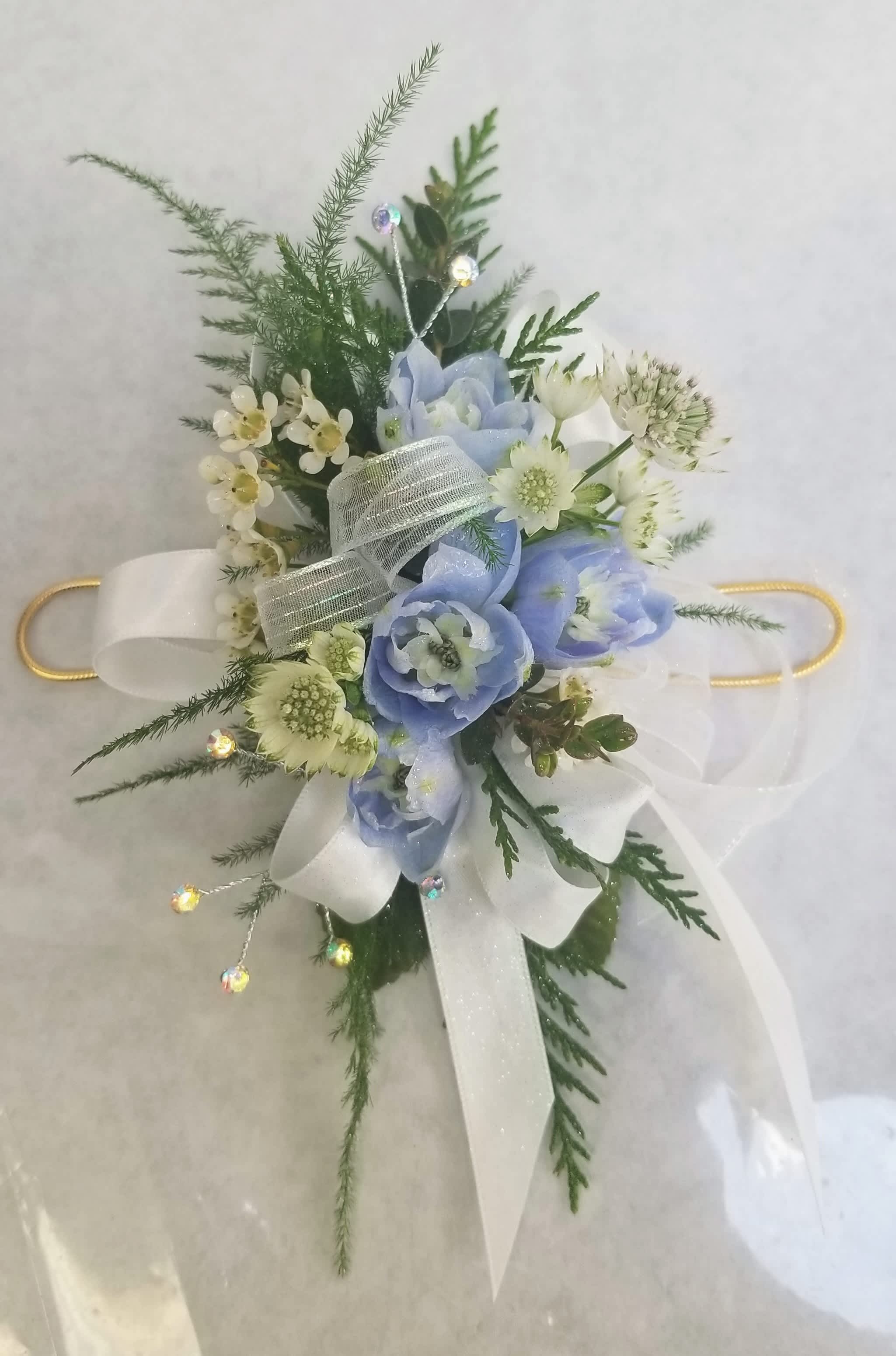 Blue Garden Wrist Corsage - this beaultiful blue garden wrist corsage created with seasonla blooms in a medium size *** our most popular, and accented with cream ansd gold on an adjustable wire band.  Personalize your corsage by choosing flower color, size, accents and band.