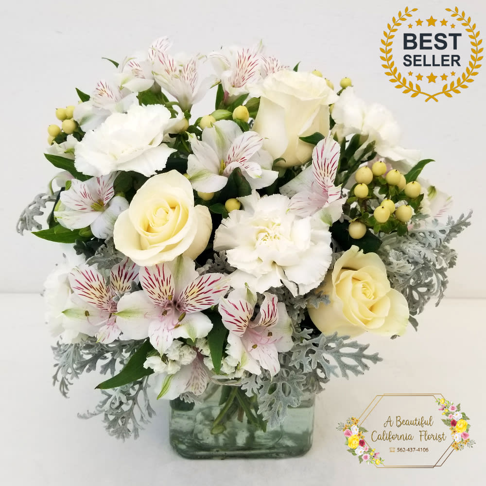 Vendela Vendela - Vendela, creamy white roses, ivory alstromeria, fragrant carnations, light grey dusty miller, with accents of white hypericum, arranged in modern cube vase. It is an elegant and classic choice for home or office. Approximate size is 12" Tall x 12" Wide and will fit well on a desk, entry or coffee table, or counter top. Vendela from Long Beach's favorite flower shop, A Beautiful California Florist. We offer same day flower delivery or pickup, give us a call or order online.