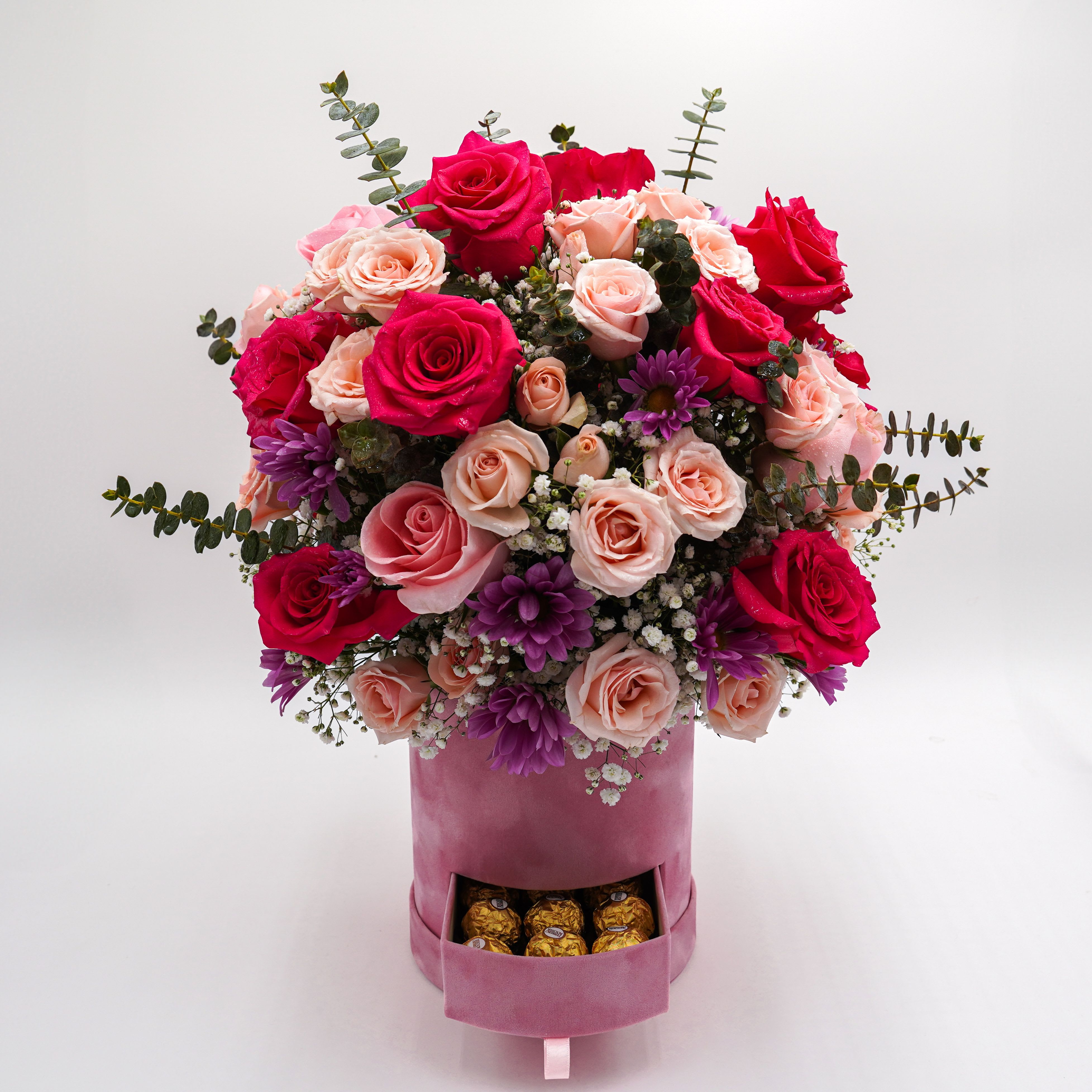 Be Mine - Includes hot and light pink roses, pink spray roses, lavender daisies, baby breaths, and baby eucalyptus.   There are also a couple of chocolates inside the container box.  Soft Plush Box Material Size: 8 x 7  