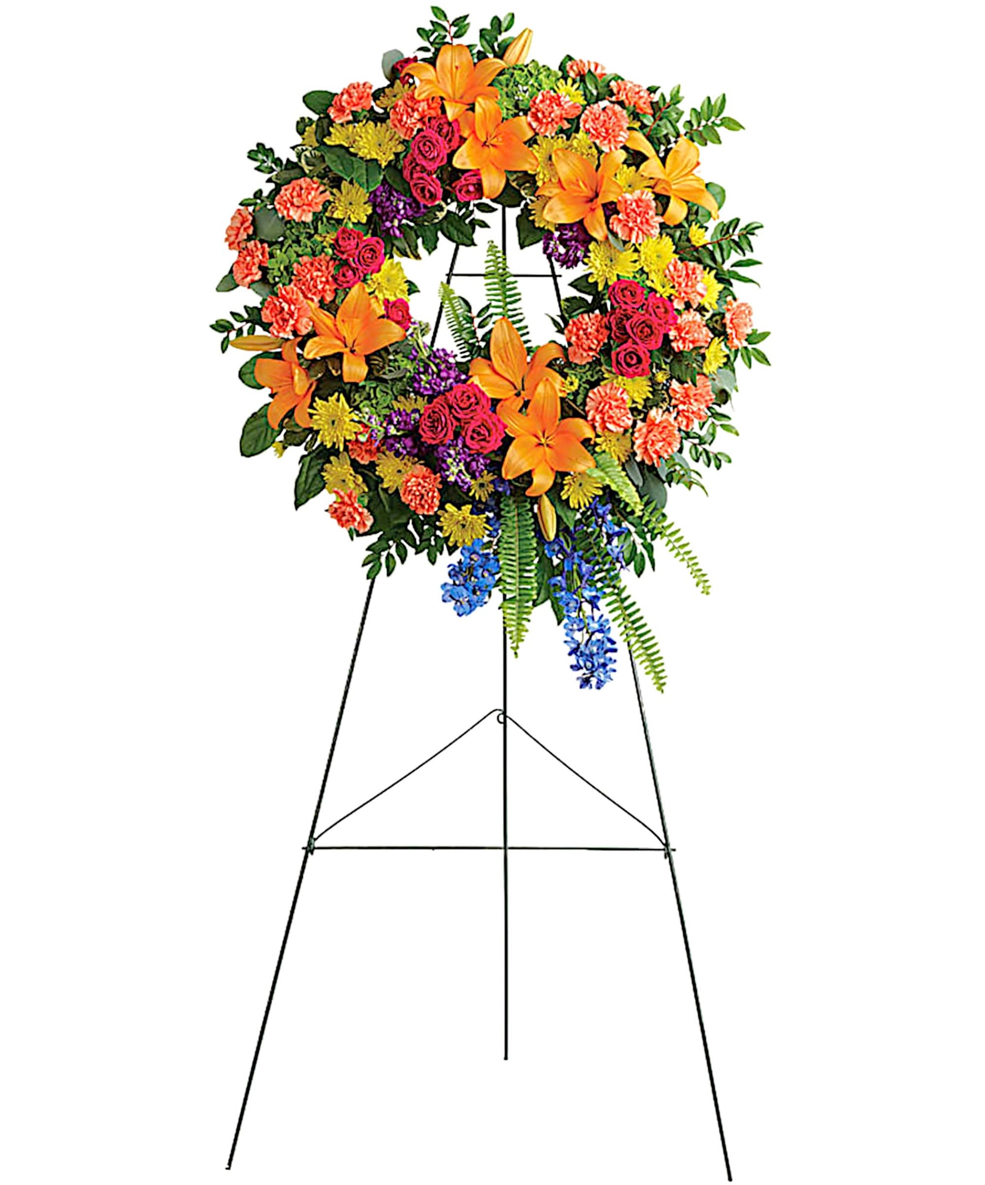 Colorful Serenity Wreath - Like a beacon of love and hope, this glorious wreath of hydrangea, roses and lilies echo the joy of your precious memories. A grand display appropriate for the funeral home, memorial service, or gravesite.  DETAILS This wreath features green hydrangea, hot pink spray roses, orange Asiatic lilies, orange carnations, blue delphinium, purple stock, yellow cushion spray chrysanthemums, huckleberry, variegated pittosporum, sword fern, silver dollar eucalyptus, and lemon leaf.   EASEL Orientation: One-Sided *If you would like to add a ribbon with a sentiment for an additional $10 each. Item #NF-1105  FLORIST-TO-DOOR Same day flower delivery on most orders placed online by 12 pm or 10 am on weekends PST.  BLOOM DETAILS Asiatic Lilies Carnations Spray Roses Cushion-Mums Stock Delphinium Hydrangeas Greenery  The Standard Arrangement is approx. 34&quot;H x 27 3/4&quot;W The Deluxe Arrangement is approx. 38&quot;H x 30&quot;W The Premium Arrangement is approx. 42&quot;H x 32&quot;W  INSTRUCTIONS: 1.) Please have the business name of the funeral home, address &amp; phone number. 2.) Please have the first name &amp; last name of the deceased. 3.) Please have the start time of the services. 4.) If you would like for us to write a brief message on a small business card-size note, please have your message ready.  NINFA'S FLOWERS 2405 WHITTIER BLVD. LOS ANGELES, CA. 90023