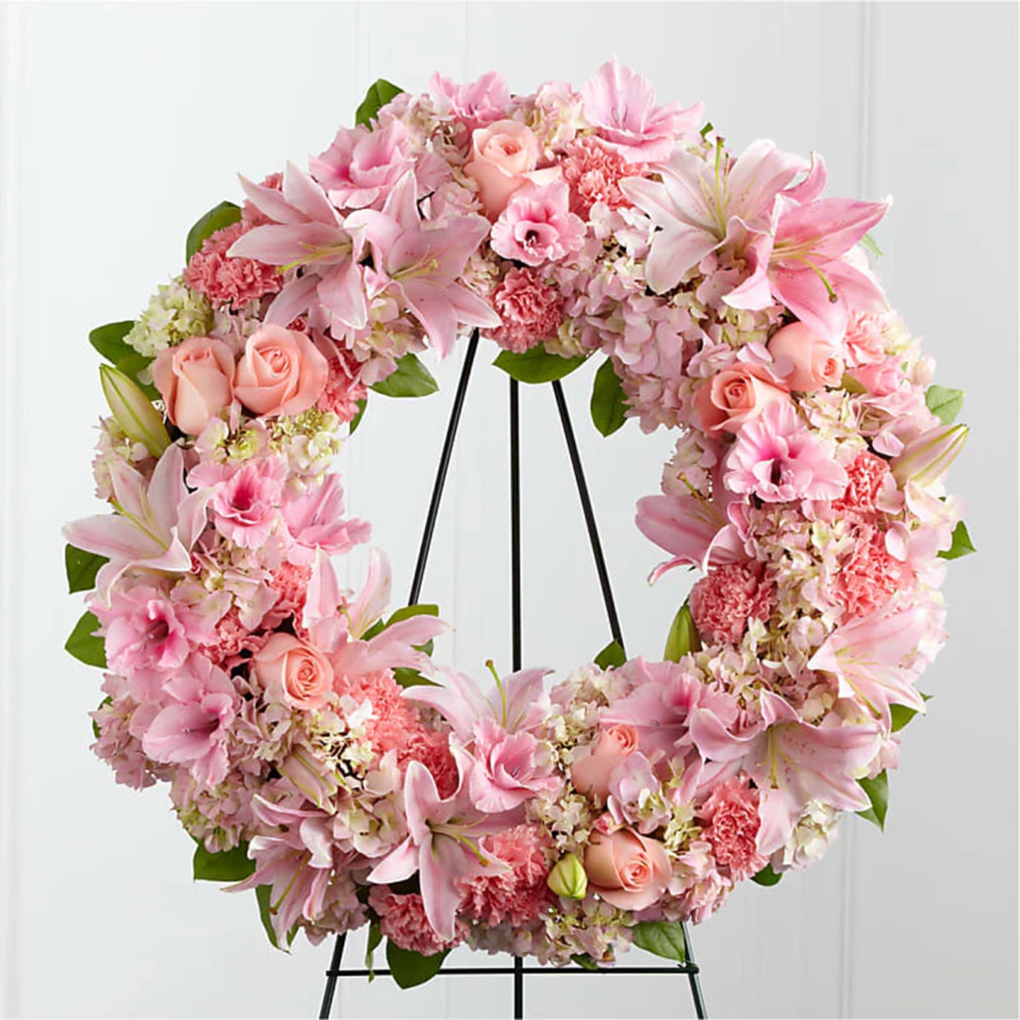Loving Remembrance Standing Wreath - The Loving Remembrance Wreath is a blushing display of grace and beauty to honor the life of the deceased at their final tribute. Appropriate for the funeral home, memorial service, and gravesite.  DETAILS Pink roses, Asiatic lilies, pink gladiolus, pink and white hydrangeas, and pink carnations are brought together with lush greens, offering warmth and comfort with its sweetly sophisticated elegance.   EASEL INCLUDED Orientation: One-Sided *If you would like to add a ribbon with a sentiment for an additional $10 each. Item #NF-1186  FLORIST-TO-DOOR Same day flower delivery on most orders placed online by 12 pm or 10 am on weekends PST.  BLOOM DETAILS Roses Gladiolus Asiatic Lilies Hydrangeas Carnations Greenery  The Standard Arrangement is approx. 22&quot; in Diameter without an easel.  The Deluxe Arrangement is approx. 25&quot; in Diameter without an easel. The Premium Arrangement is approx. 28&quot; in Diameter without an easel.  INSTRUCTIONS: 1.) Please have the business name of the funeral home, address &amp; phone number. 2.) Please have the first name &amp; last name of the deceased. 3.) Please have the start time of the services.  NINFA'S FLOWERS 2405 WHITTIER BLVD. LOS ANGELES, CA. 90023