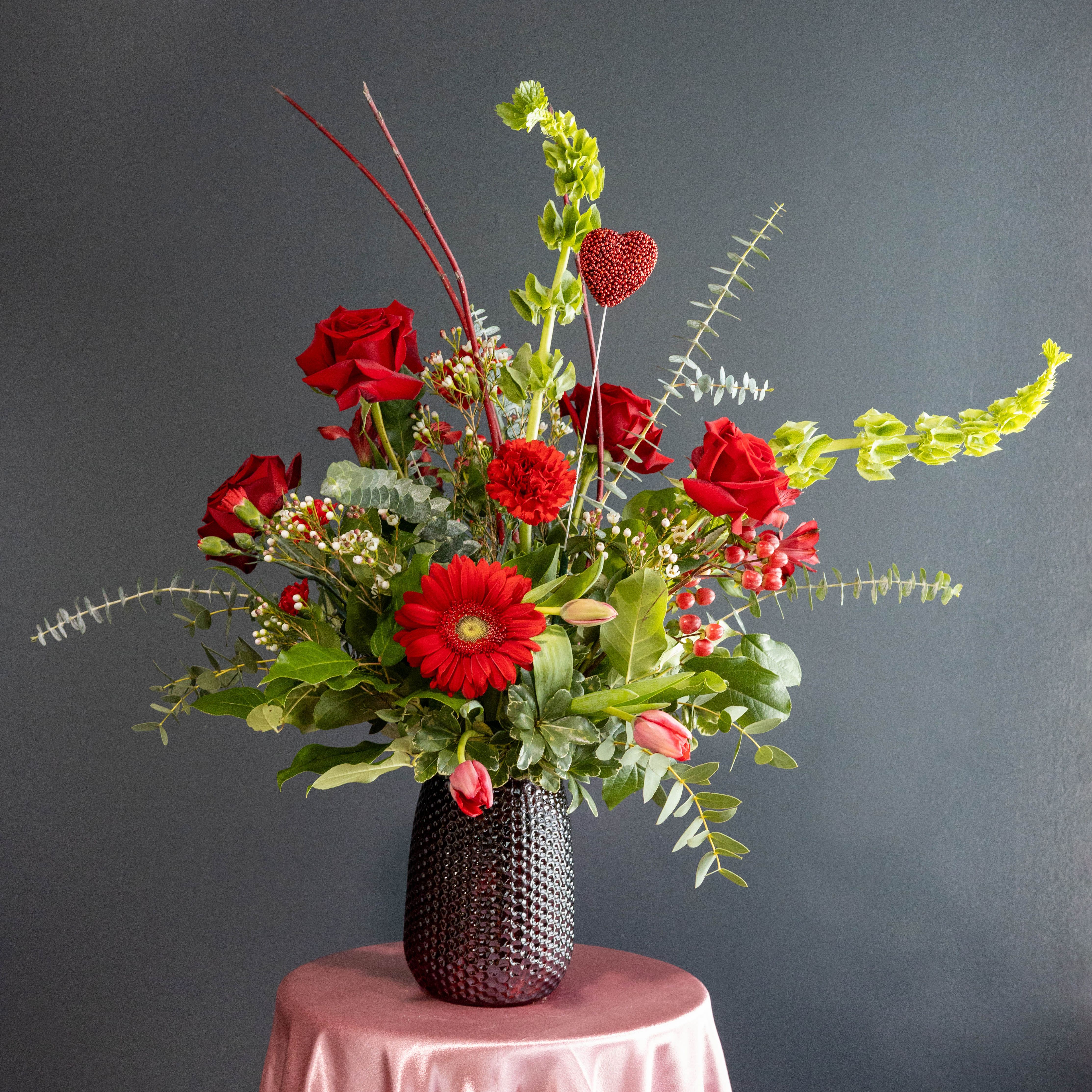 Envy - Want to send an arrangement to your special someone that will make others green with envy? This arrangement with it's red roses, red tulips, red carnations, and more will do just that!