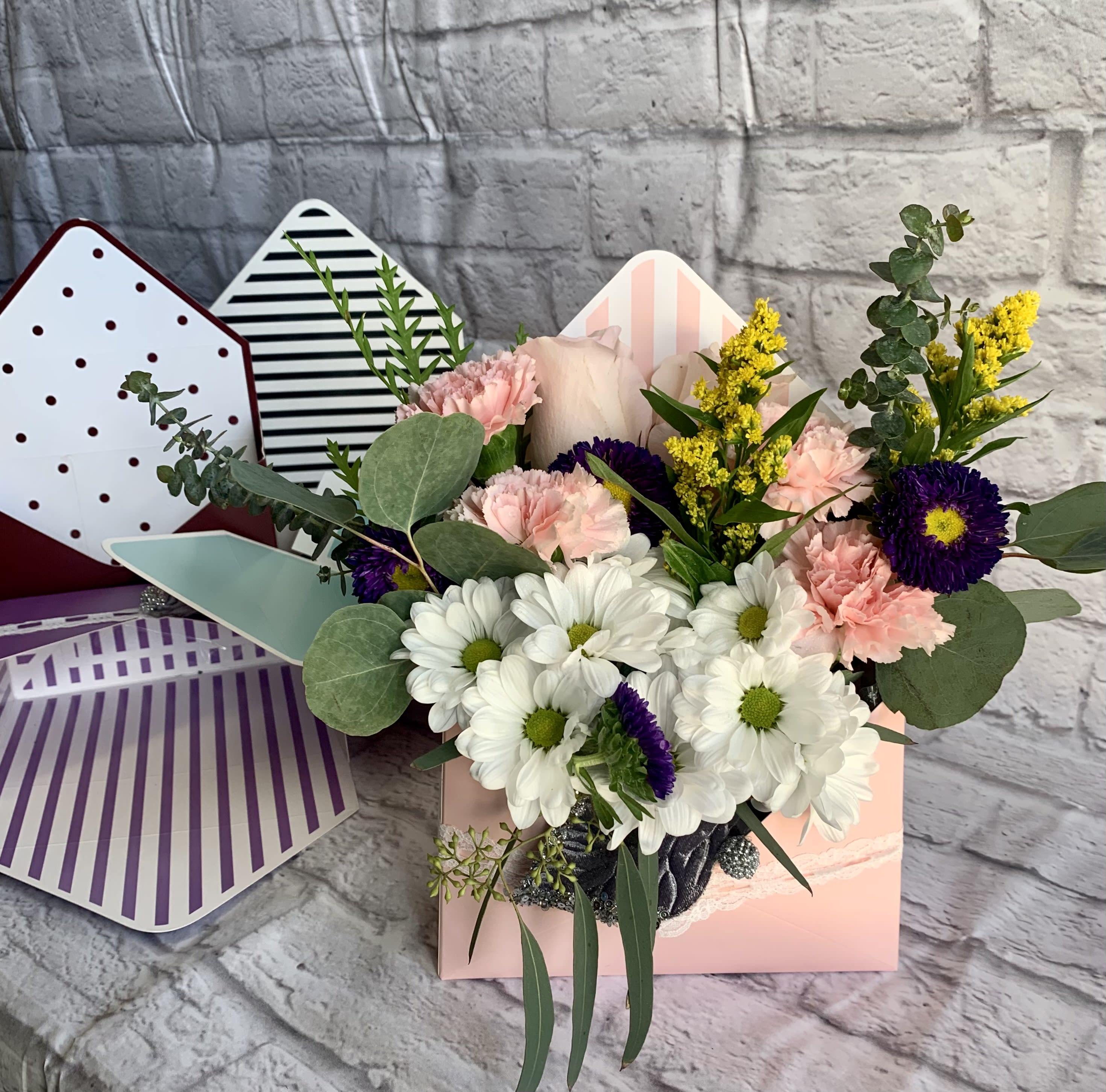 Love Letter Love Letter - Just like a love letter, each one uniquely written pouring out feelings from the heart.! Beautiful fresh flowers fill an envelope shaped box. Your florist will select one of a variety of colored envelopes and custom design your order specifically for your recipient. Color of envelope and flowers will vary in color. (All designs are arranged as similar as possible. We promise to keep the same color, style, and overall theme with what Mother Nature generously blesses us with. The candle wax is available in earth toned colors.)
