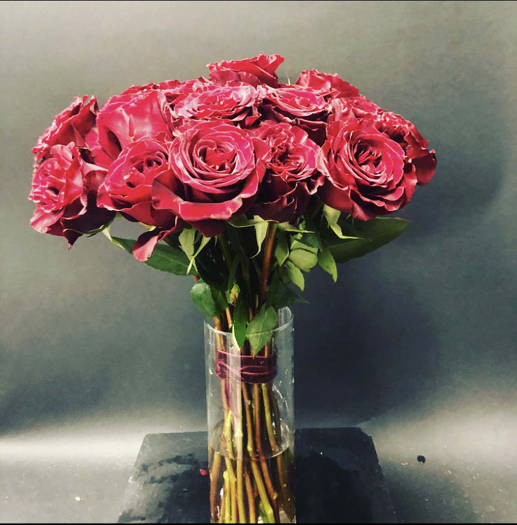 Amore Mio  - Red roses, 2 dozen. Wrapped stems with ribbon in a glass vase. Simple, beautiful holiday feel.