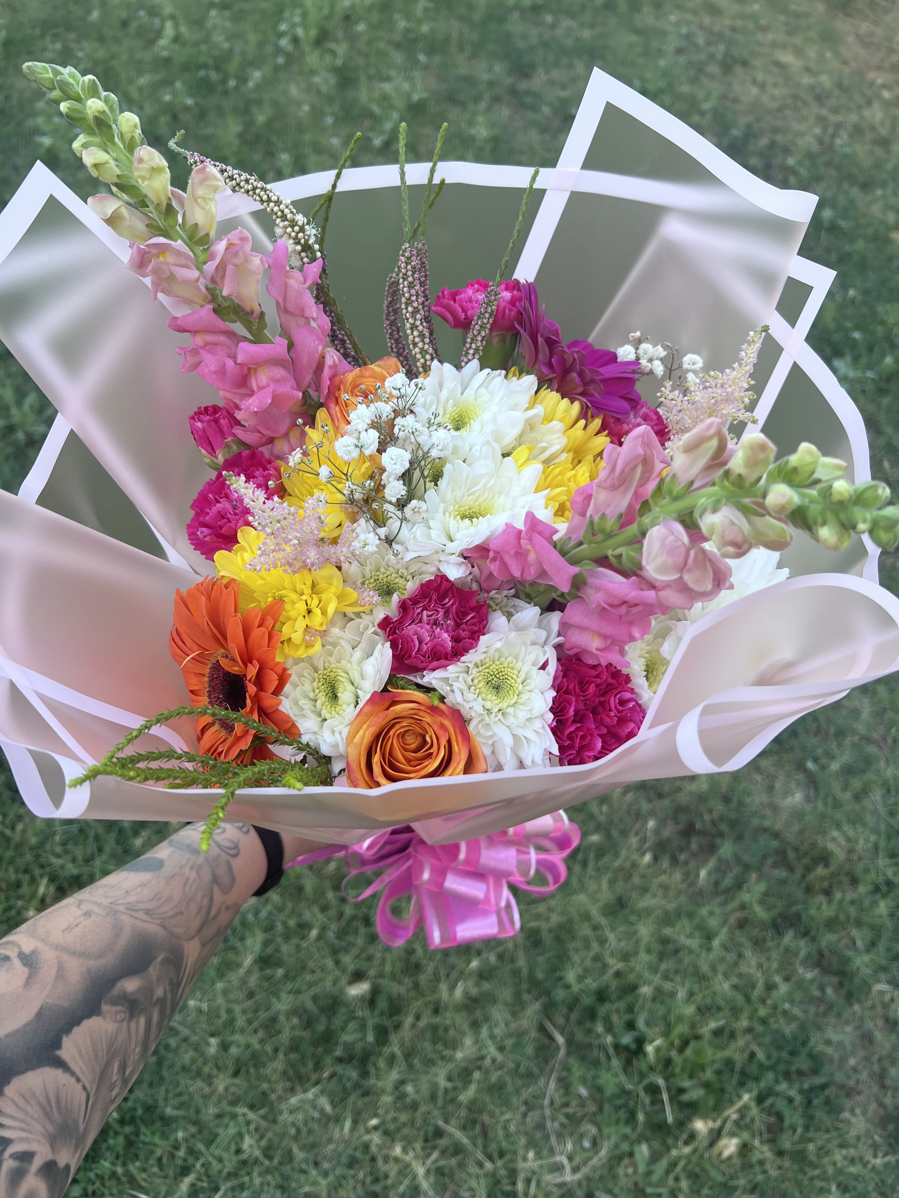 Spring Blooms  - A dainty mix of seasonal flowers wrapped in paper and tied with a bow. 