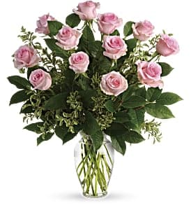 One Dozen Long Stem Pink Roses - Say it sweeter with this feminine bouquet of a dozen pink roses (Standard) and lush greens in a graceful glass vase.  