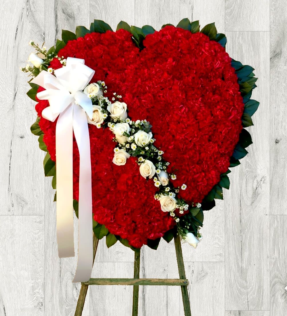 Red and White Heart-Shaped Standing Spray Red and White Heart-Shaped Standing Spray - When someone so dear passes, a standing tribute is a fitting way to pay respects. Our impressive standing spray arrangement, meticulously handcrafted by expert florists with pristine red carnations and white roses and waxflowers, is a lush, full presentation that makes for a proud and respectful commemoration.