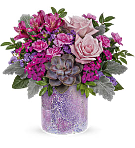  Lovely Shine Bouquet - As magical as sunset in the desert. Luscious pink roses and a sculptural succulent get the glamorous treatment in a shimmering mosaic glass vase. This chic bouquet features light pink roses, purple alstroemeria, miniature lavender carnations, dark pink sweet william, lavender sinuata statice, dusty miller, huckleberry and a large green faux echeveria succulent plant. Delivered in Teleflora's Shining Beauty cylinder. Approximately 13&quot; W x 12 1/4&quot; H