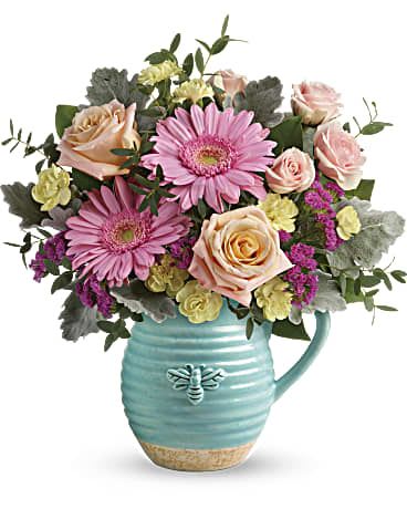 Bee Delighted Bouquet - This delightful bouquet includes peach roses, pink spray roses, pink gerberas, yellow miniature carnations, raspberry sinuata statice, parvifolia eucalyptus, dusty miller, and lemon leaf. Delivered in a Busy Bee pitcher. Who could help but &quot;bee delighted&quot; by this sweet surprise! Bursting with spring-fresh pink and peach blooms, this charming country-inspired ceramic pitcher is sure to be a favorite food-safe keepsake! Approximately 13 1/2&quot; W x 15&quot; H