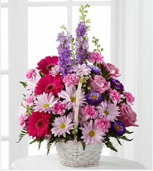 Pastel Peace Basket Arrangement - The Pastel Peace Basket is a sweet and simple way to offer your condolences. Lavender roses, fuchsia gerbera daisies, lavender daisies, purple larkspur, purple matsumoto asters, pink mini carnations and lush greens are arranged to perfection in a round whitewash handled basket to create a gift that expresses your wishes for sympathy and peace.