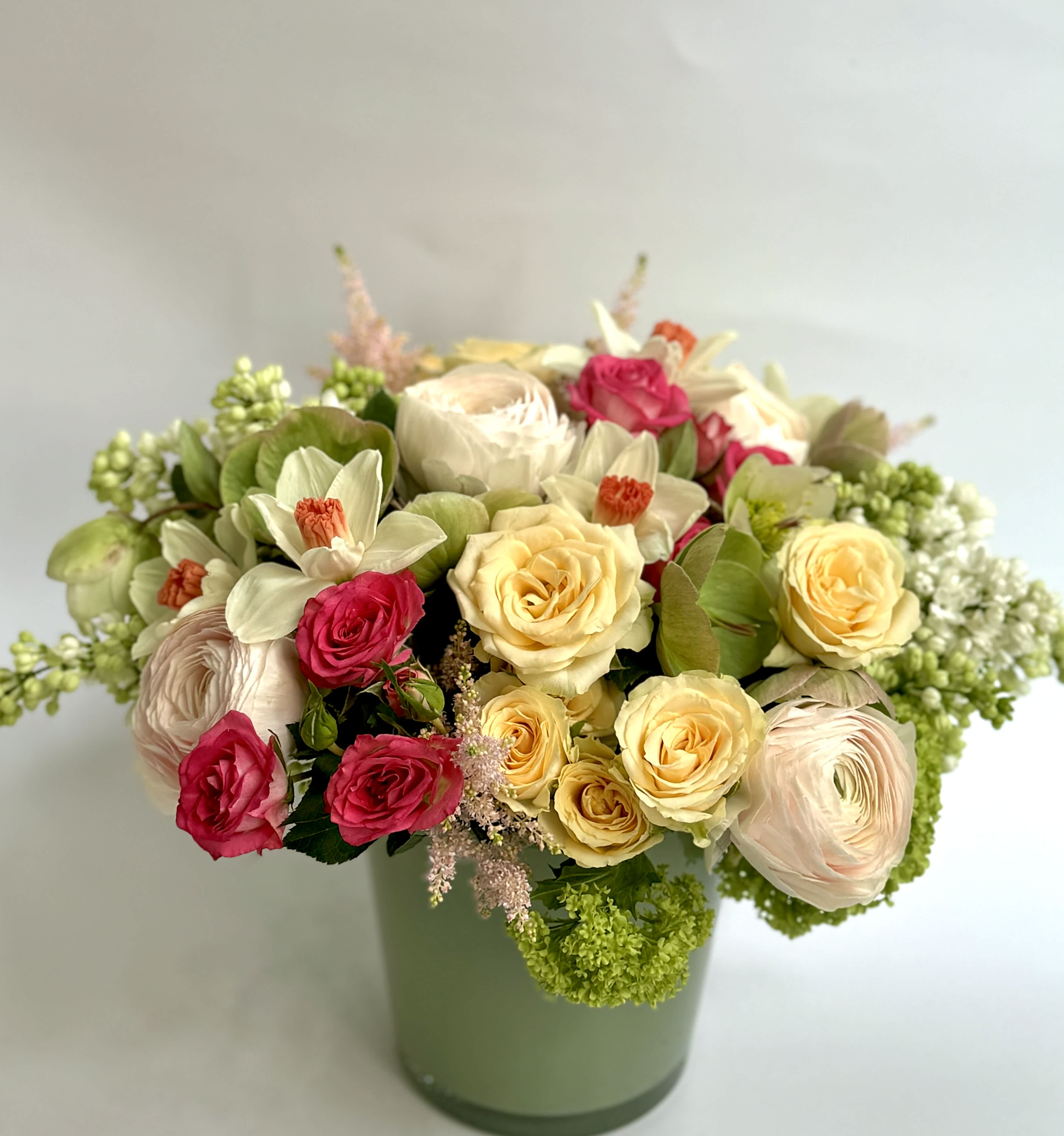 Delilah - Pastels tone Roses and Ranunculus are the center of this beautiful seasonal arrangement.