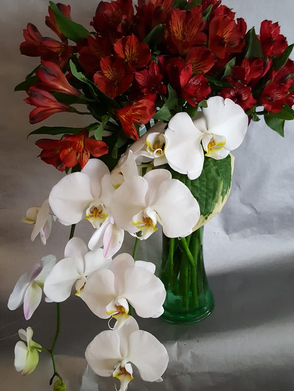 Extreme and Elegant Perfection Extreme and Elegant Perfection - Clear antique green glass vase of Phalaenopsis Orchid, Peruvian Lilies and Hosta leaves