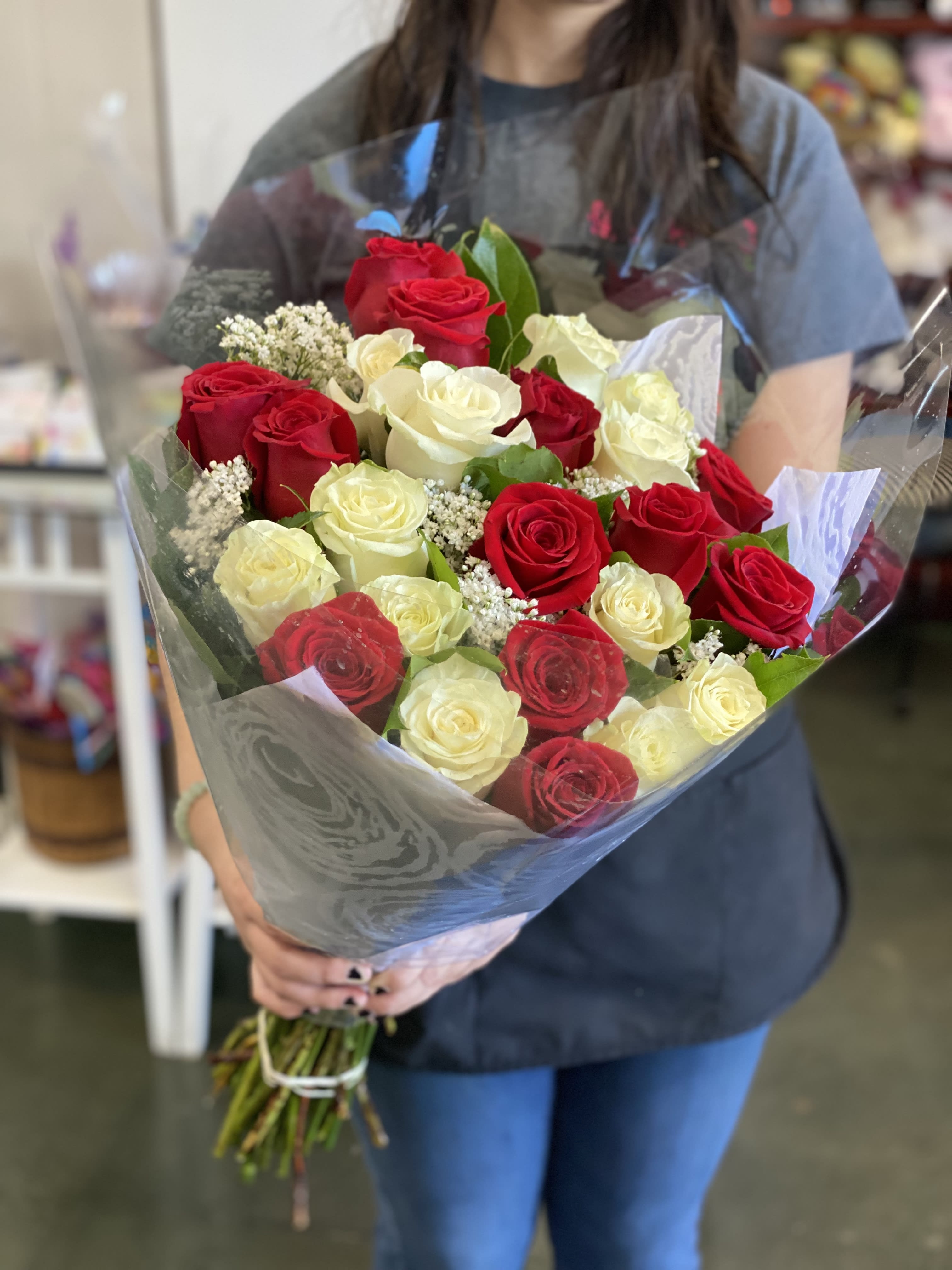 Traditional wrapped 24 Roses - Wrapped in cellophane/plastic paper and a simple colored Polyester paper. These are one of our favorites to have for all our walk in customers. You will typically find these available for grab-&amp;-go’s.  Please add in instructions you color choice of roses during checkout.  NO SPECIAL WRITING ON PAPER AVAILABLE FOR THESE.