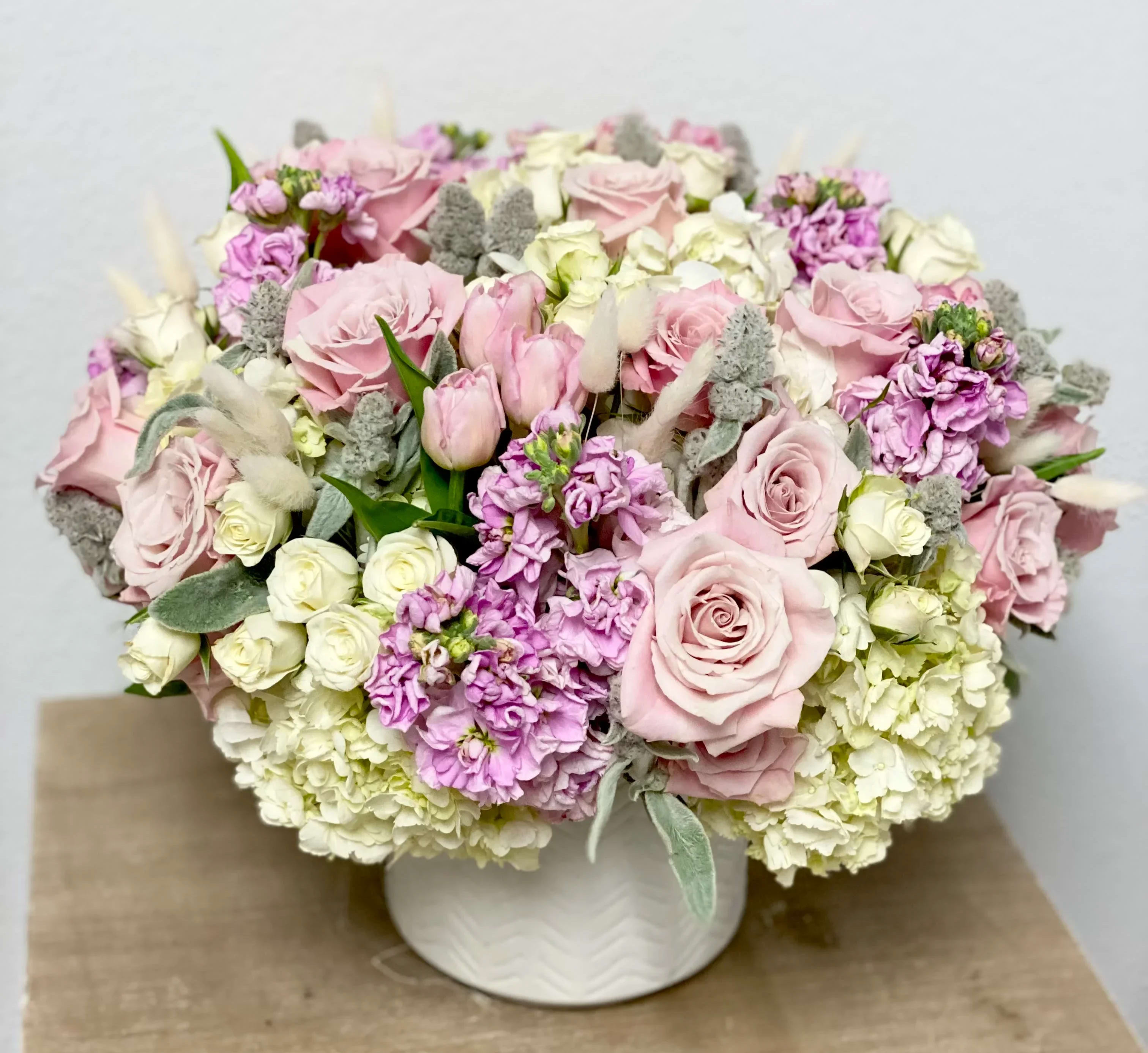 Soft pinks - Arrangement in a vase with white and soft pink flowers and dried grass.
