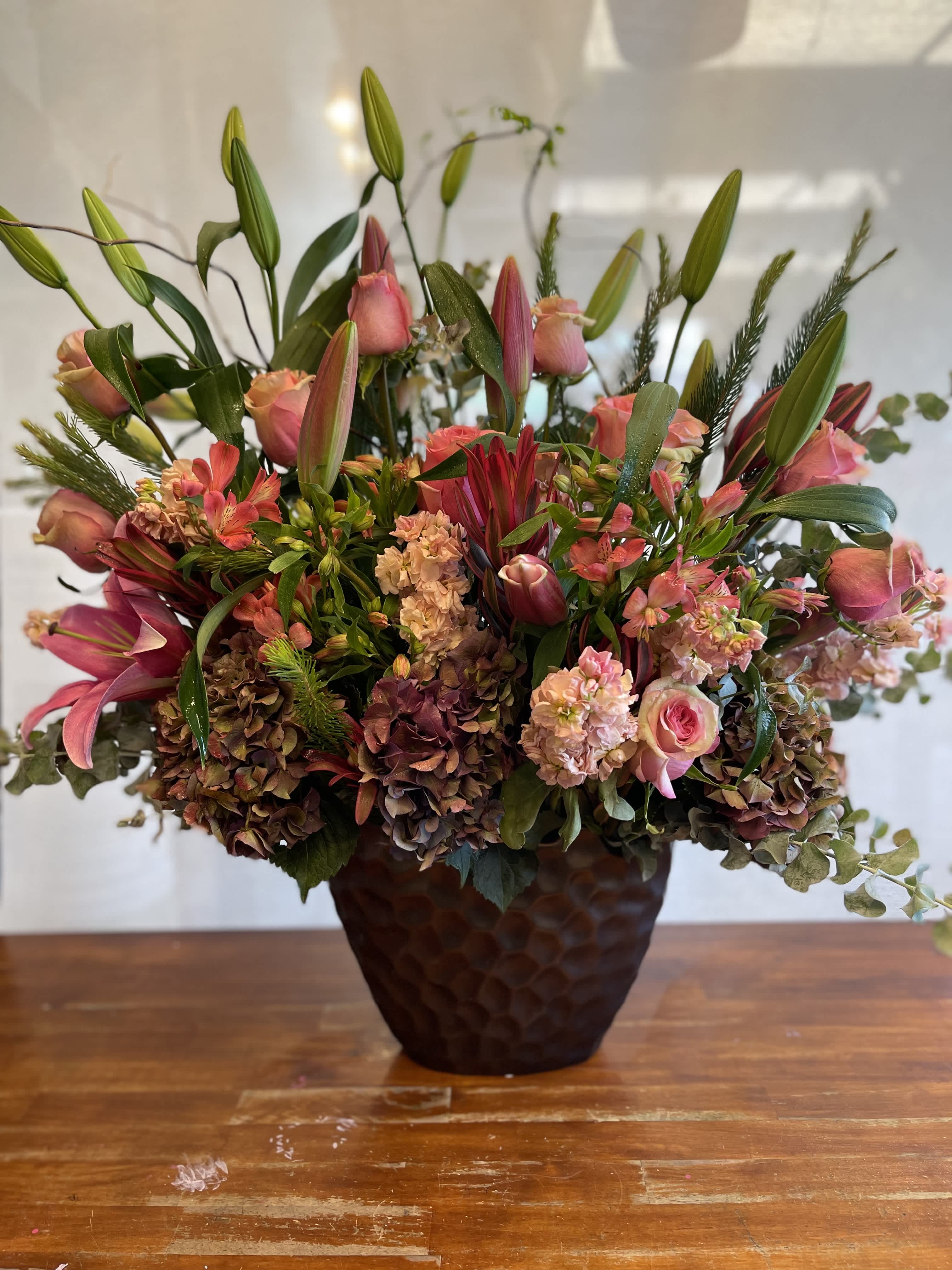 Statement of Joy Statement of Joy - Discover pure charm with our arrangement boasting pink stargazers and roses. This captivating blend of enchanting stargazers and soft pink roses creates a stunning display that exudes elegance and grace. Elevate the room with this beautiful arrangement, perfect for adding a touch of sophistication to any setting.