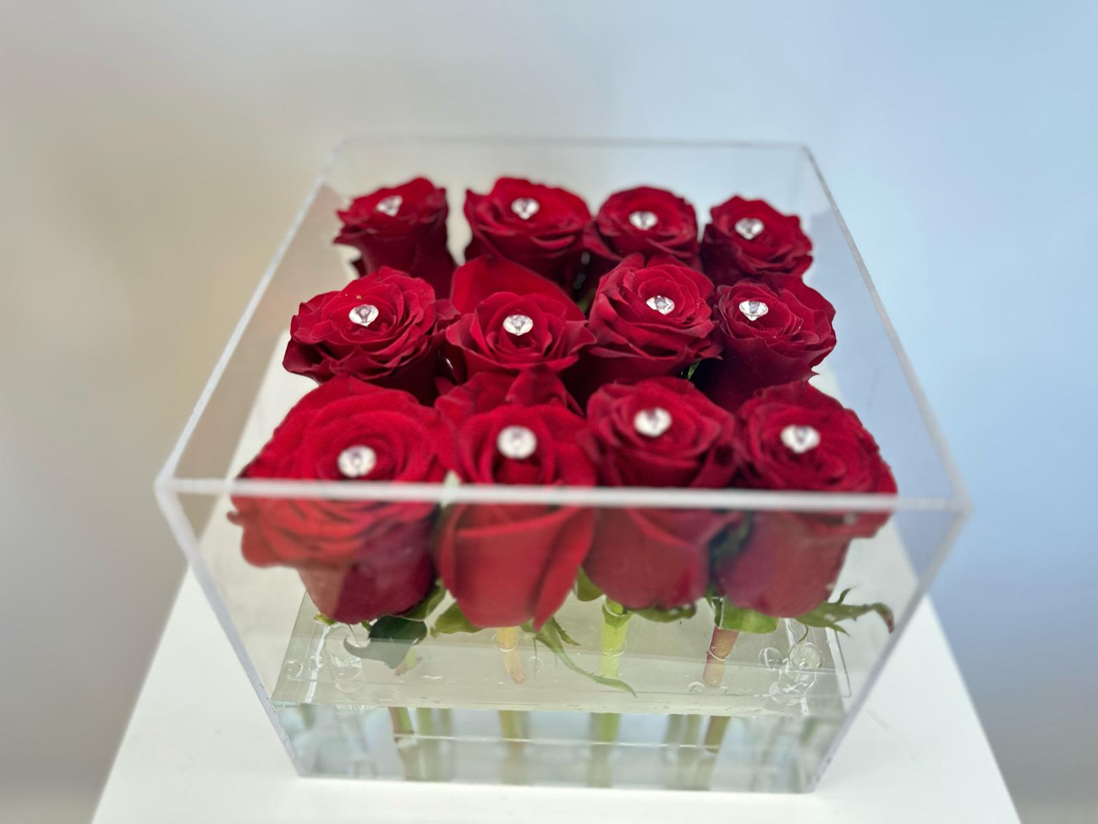 Luxury Crystal Blooms with Diamonds   - Unveil the timeless beauty of our Clear Box of Roses. Delicate petals unfold within a crystal clear container, revealing a bouquet of freshly picked roses in all their glory. The transparent case allows for 360 degrees of admiration, showcasing the roses' perfection from every angle. 