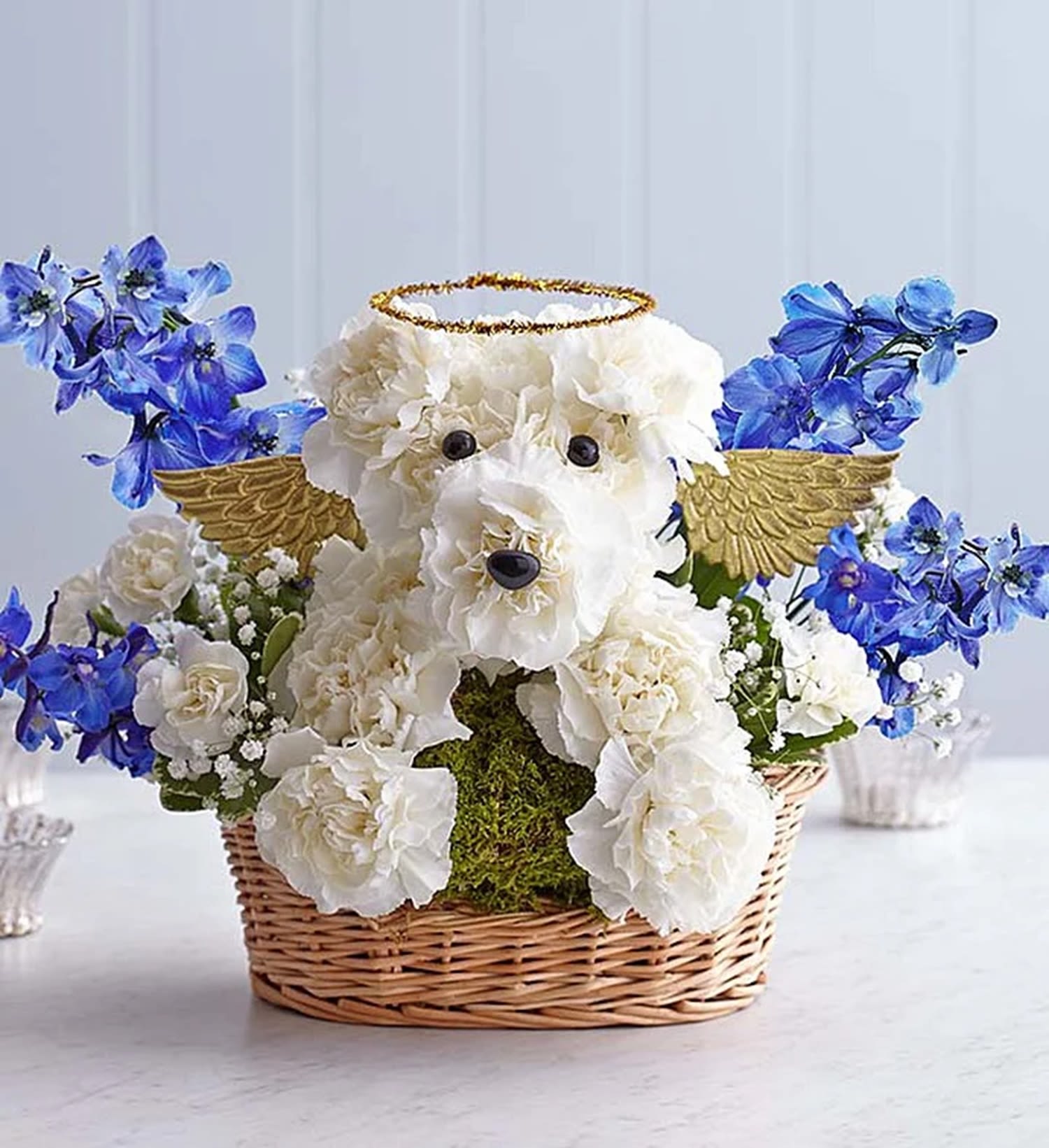 All Dogs Go to Heaven - Send your deepest sympathies for the loss of a loved one, or the loss of a beloved pet with our heavenly dog arrangement. Hand-arranged in the shape of an angelic dog, complete with golden wings and halo, carnations, delphinium and baby's breath, offering a lasting memorial for friends and family who were dog lovers, or to honor the passing of a canine family member.   DETAILS White carnations, mini carnations, blue delphinium, baby's breath, &amp; greenery. Crafted in the shape of a dog, complete with eyes, nose, halo, and wings.  BASKET INCLUDED  Orientation: One-Sided Item #NF-477  FLORIST-TO-DOOR Same day flower delivery on most orders placed online by 12 pm or 10 am on weekends PST.  BLOOM DETAILS Mini-Carnation Carnations Delphinium Baby's Breath Greenery  The Standard Arrangement is approx. 11&quot;H x 11&quot;W The Deluxe Arrangement is approx. 12&quot; H x 12&quot; W  The Premium Arrangement is approx. 13&quot; H x 13&quot; W  How to place an order? 1. You can place an order directly on this secure website OR 2. You can call in your order by dialing: (323) 262 - 9238 OR 3. You can visit our store (appointment recommended 323.262.9238)  NINFA'S FLOWERS 2405 WHITTIER BLVD. LOS ANGELES, CA. 90023