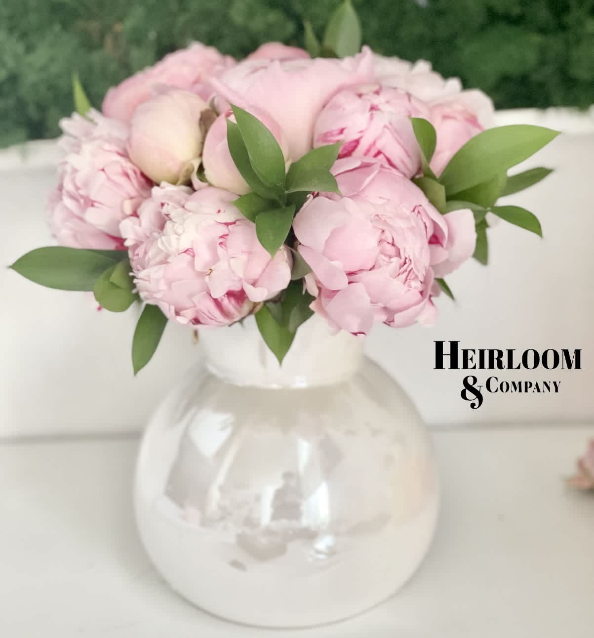 Delicate Pink Peonies Delicate Pink Peonies - An iridescent adorable vase filled with giant pink peonies and a touch of greenery to bring it all together.