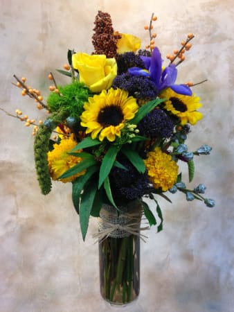Summer in a Bottle Summer in a Bottle - A cylinder filled with summer favorites: sunflowers, irises, marigolds, lantana, millet, peach ilex.